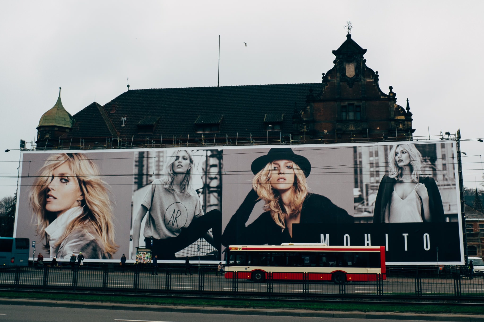Large Mochito billboard featuring models, with a bus in front.