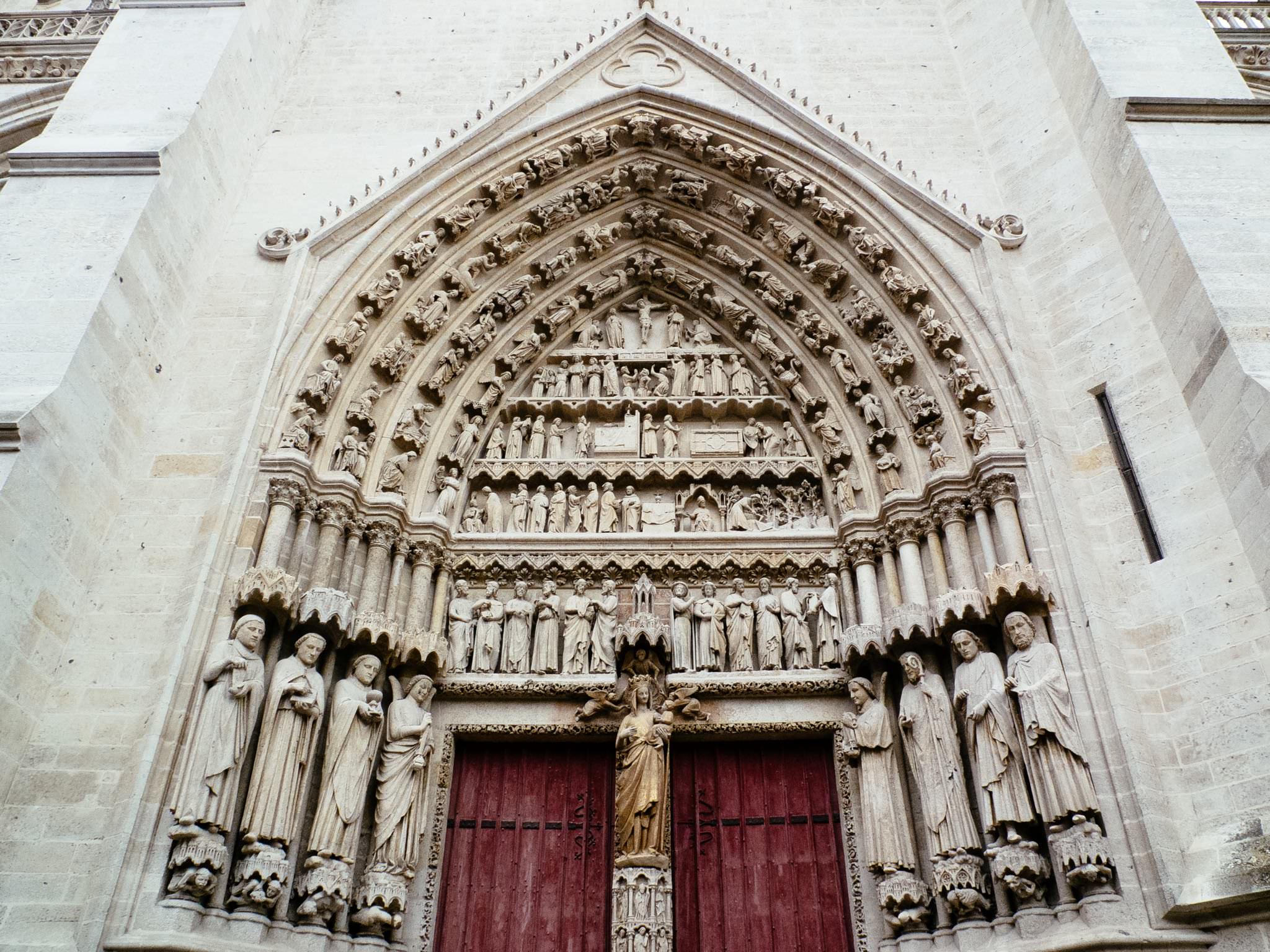 Amiens Cathedral's ornate entrance, featuring numerous statues and detailed carvings.