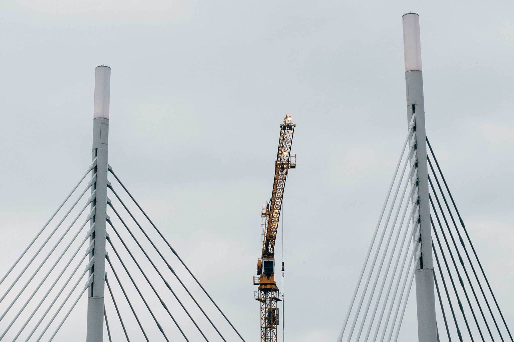 Yellow crane on a cable-stayed bridge.