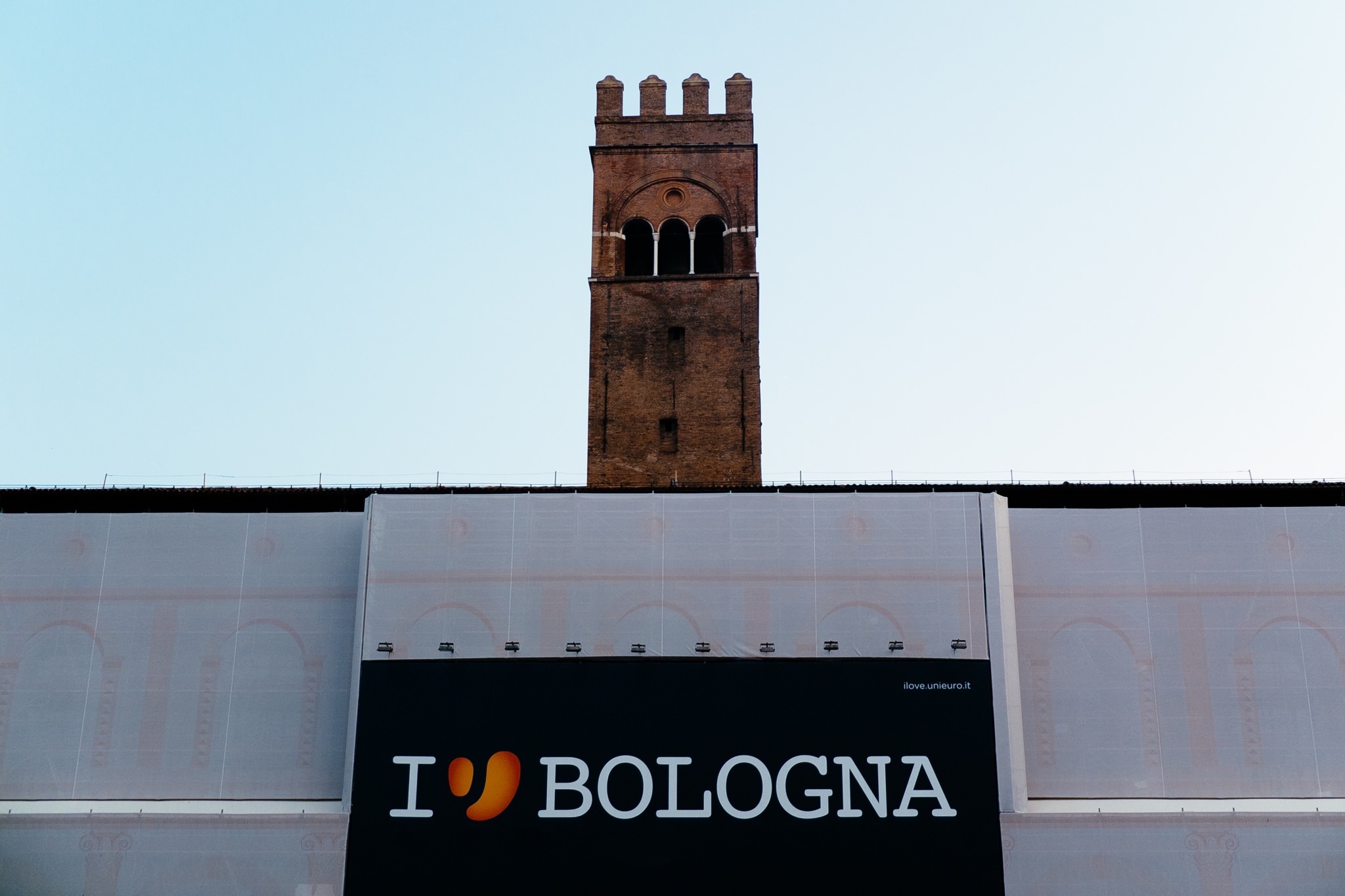 Palazzo del Podestà, Bologna, Italy, with 'I ♥ BOLOGNA' banner on scaffolding.