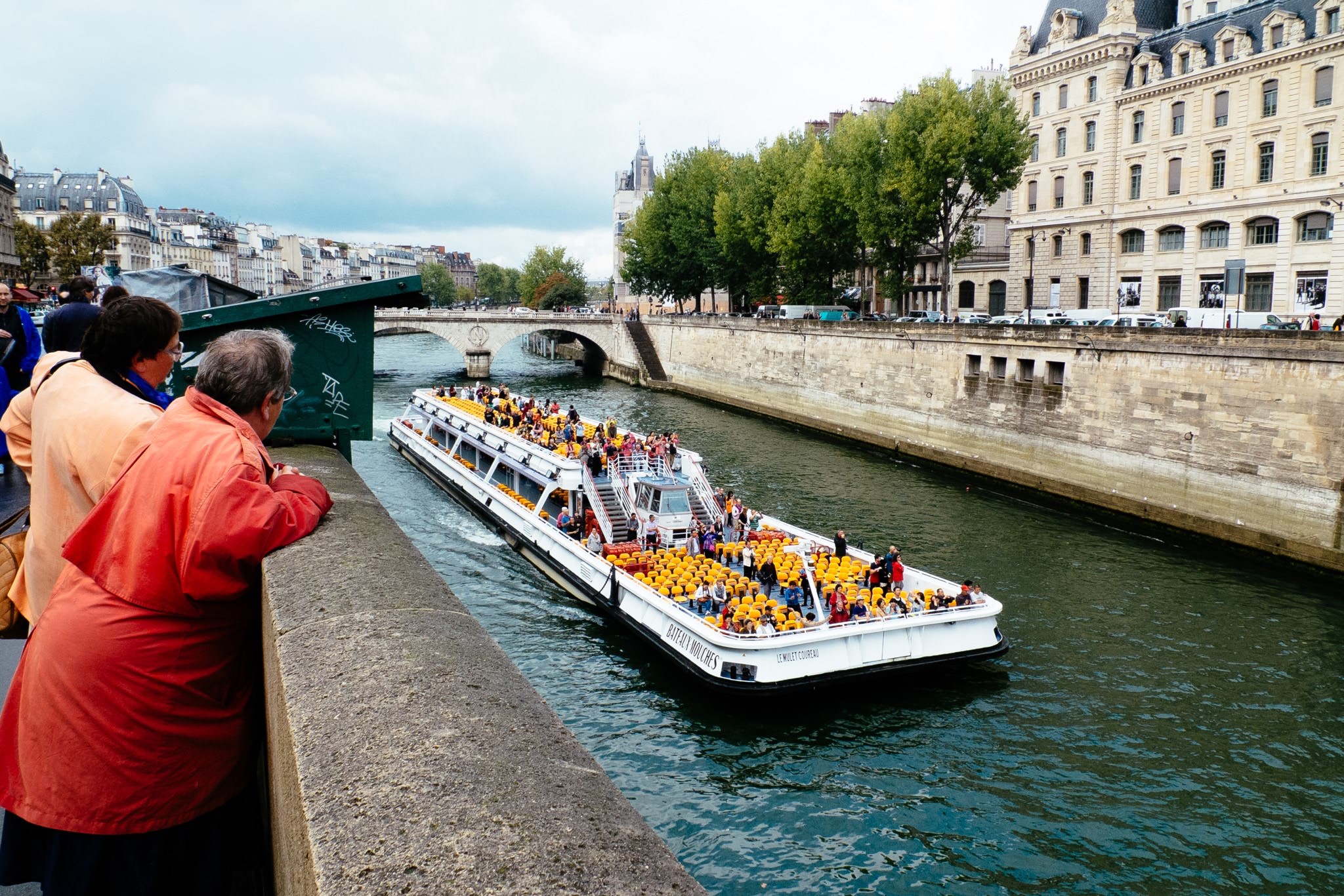 A crowded tourist boat on the Seine River in Paris.