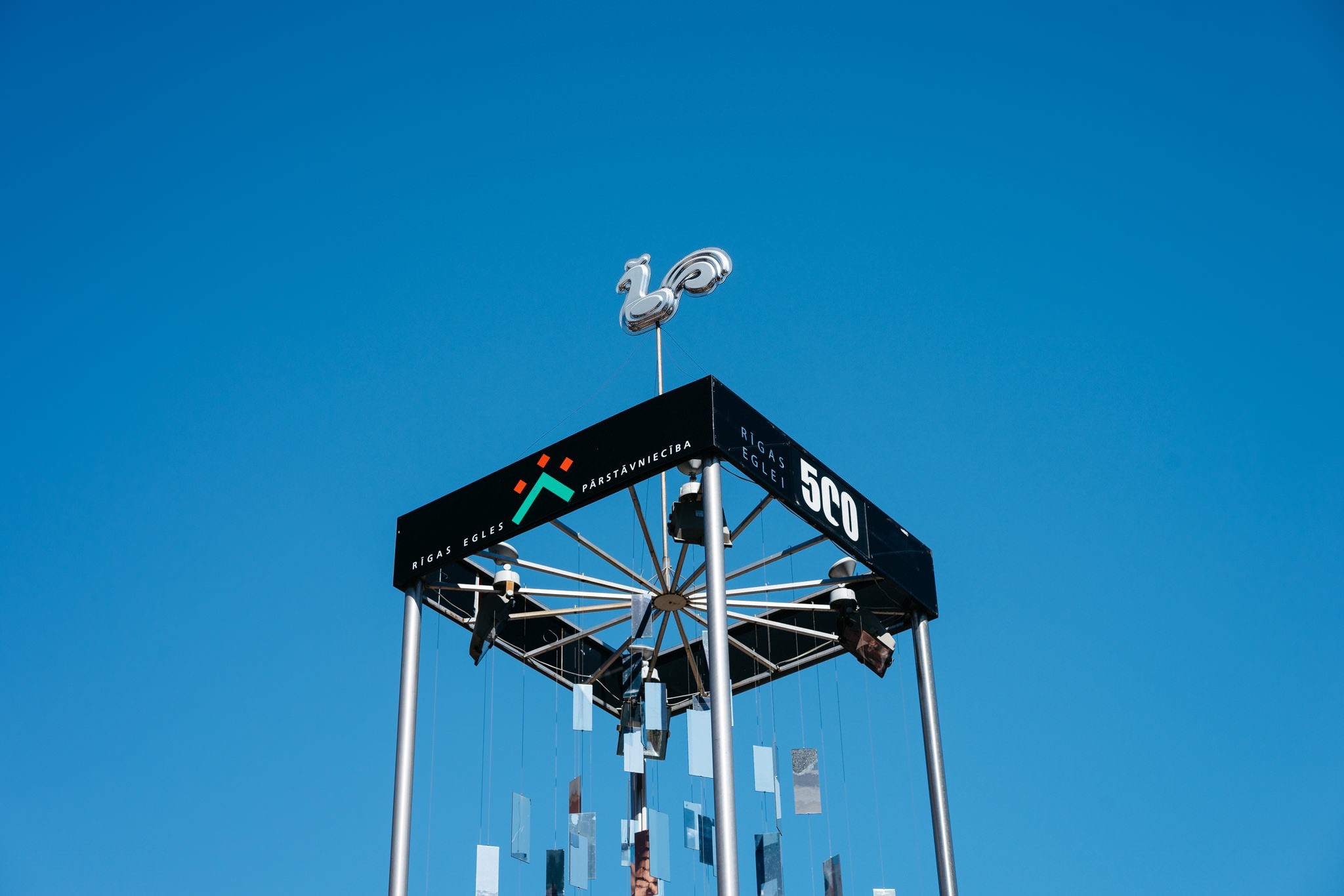 Low-angle view of a Riga Christmas tree topper against a clear blue sky.