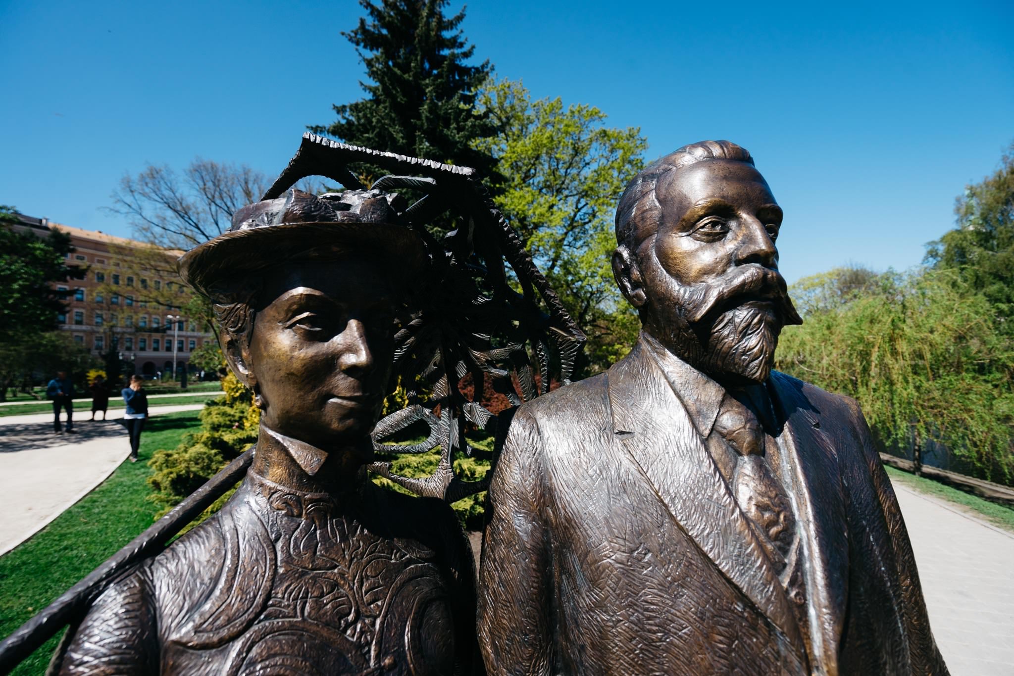 Bronze statue of a man and woman in a park.