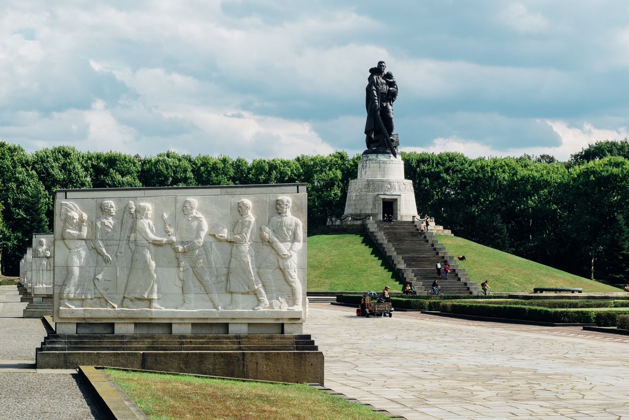 Soviet War Memorial in Treptower Park, Berlin: Large stone relief sculpture and a soldier statue.