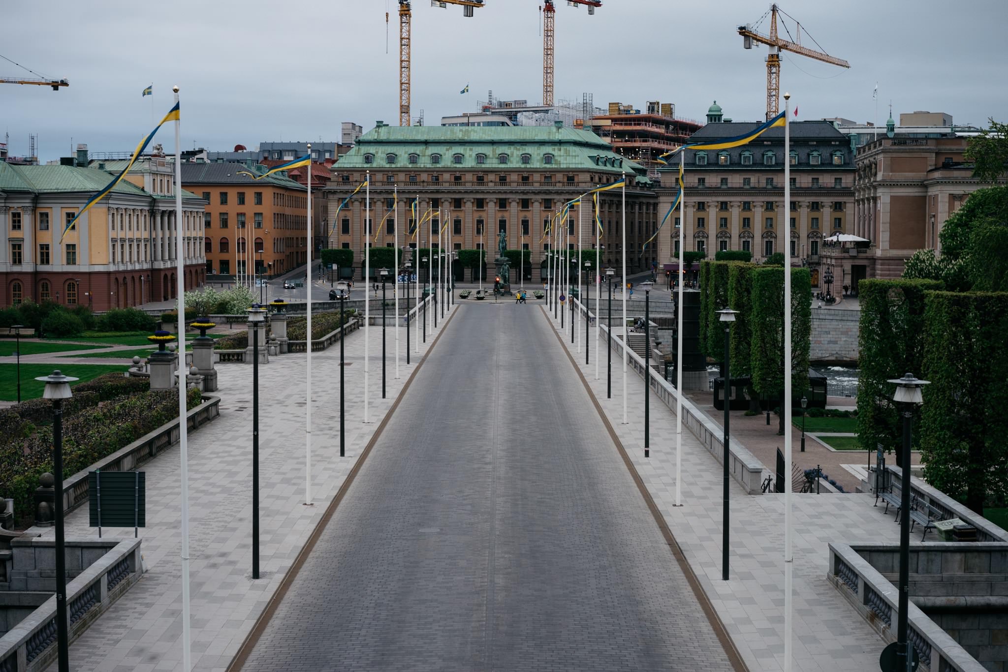 Empty Stockholm street lined with flags and buildings.
