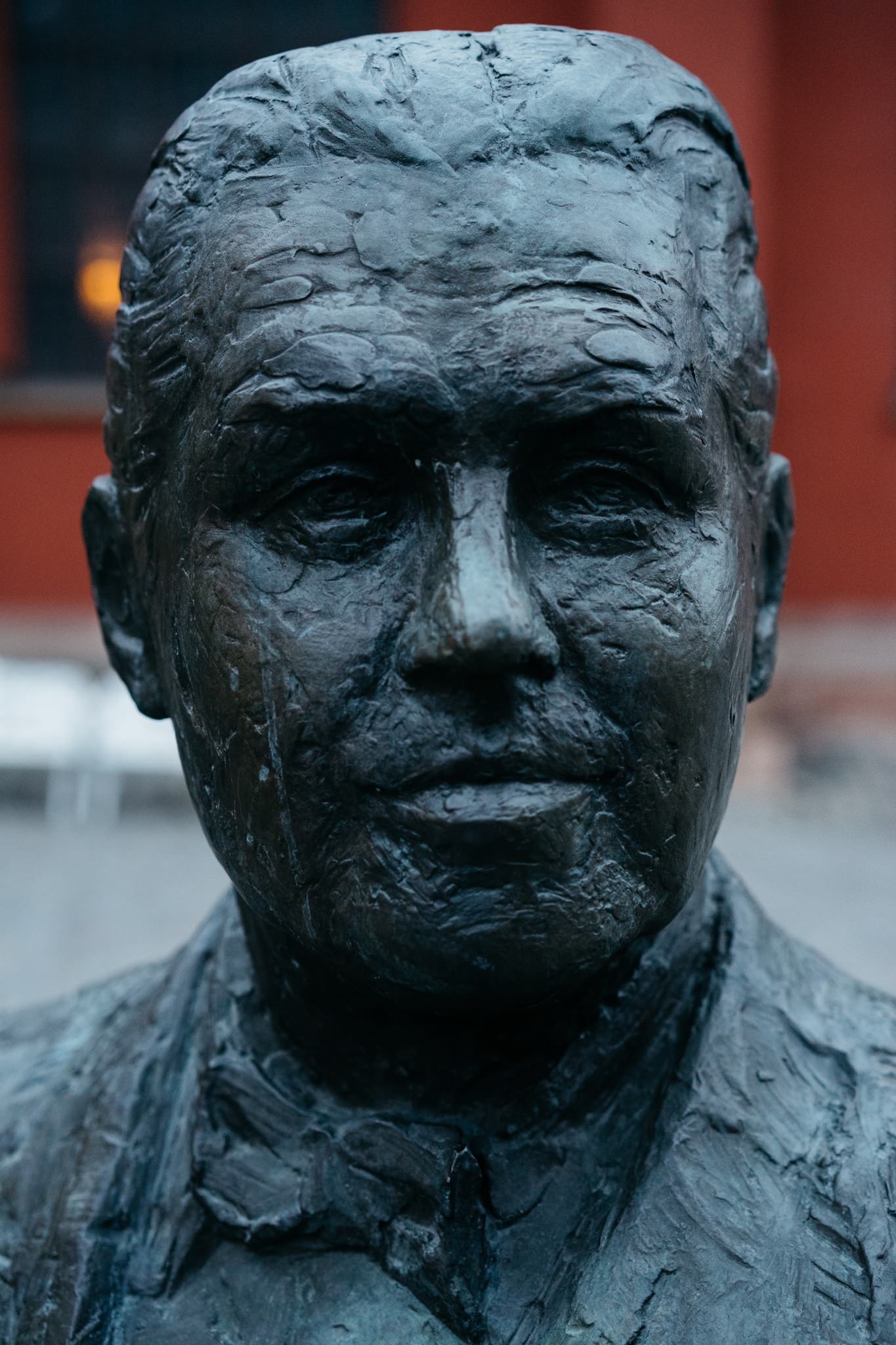 Close-up of a weathered bronze bust.