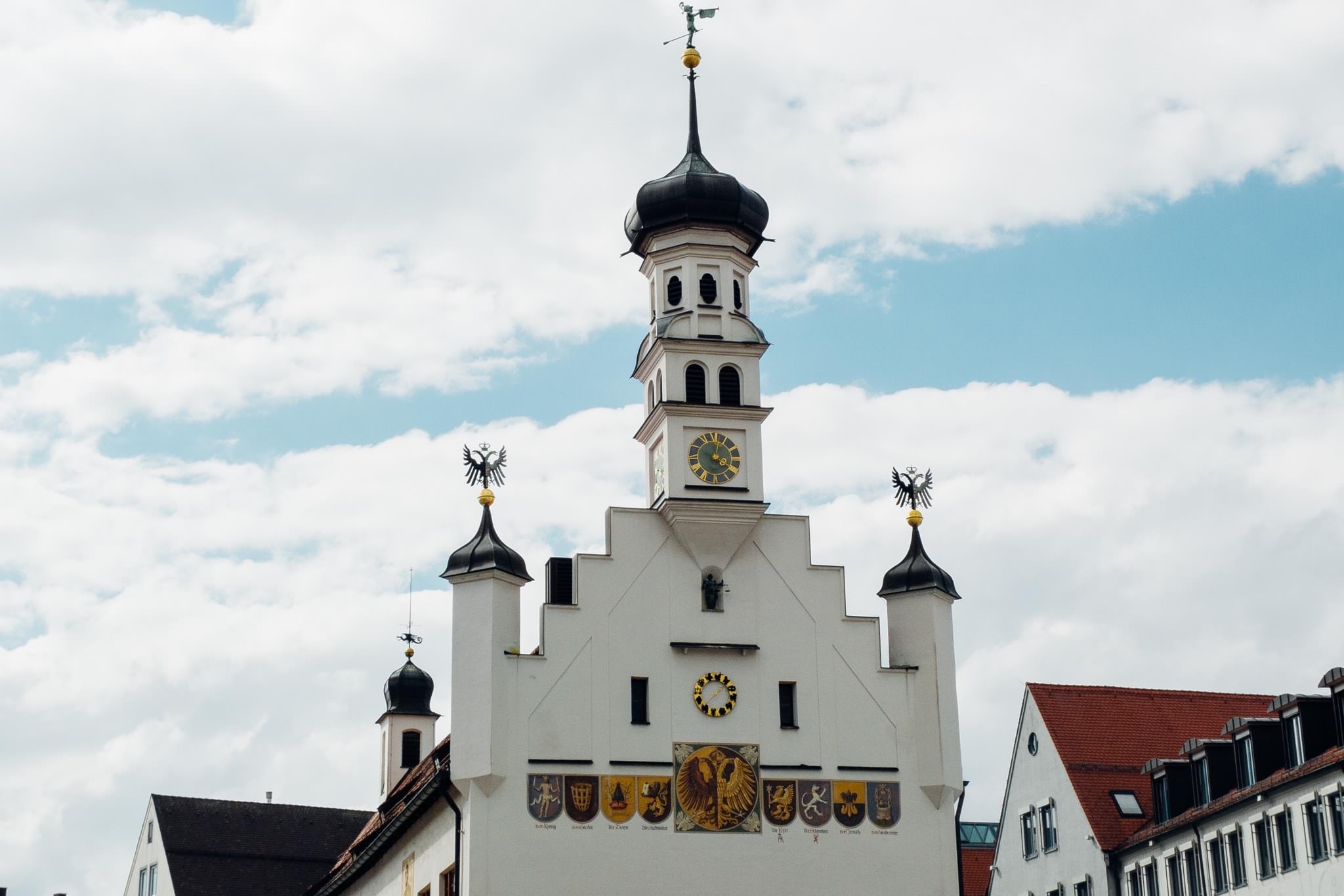 Kempten town hall with clock tower and coats of arms.
