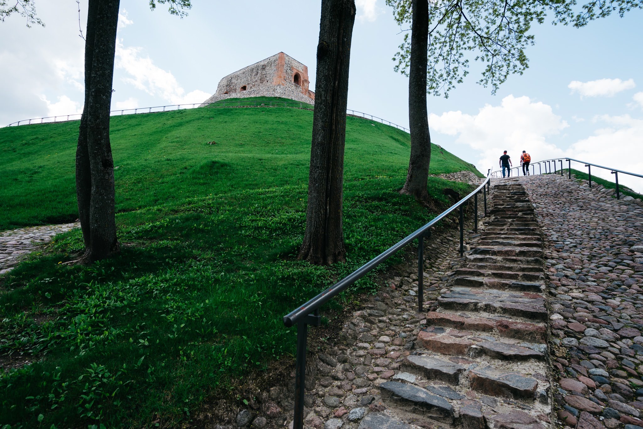 Stone staircase leading up a grassy hill to a Vilnius Upper Castle.