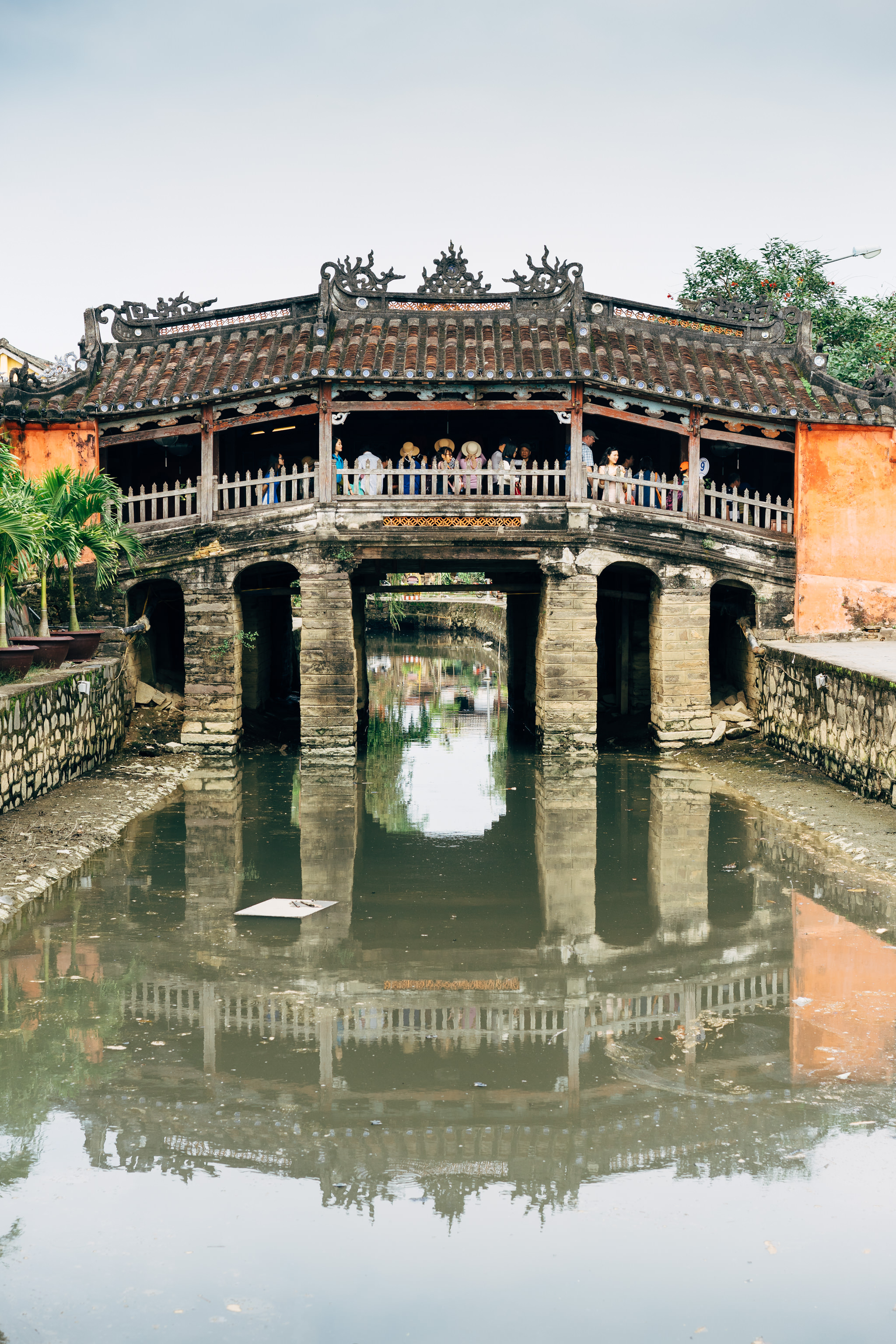 Japanese Covered Bridge in Hoi An, Vietnam, reflecting in the water.