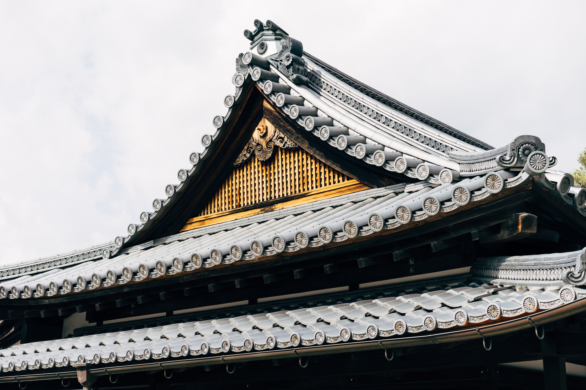Close-up of ornate gray tiled roof at Kyoto Imperial Palace, Japan.