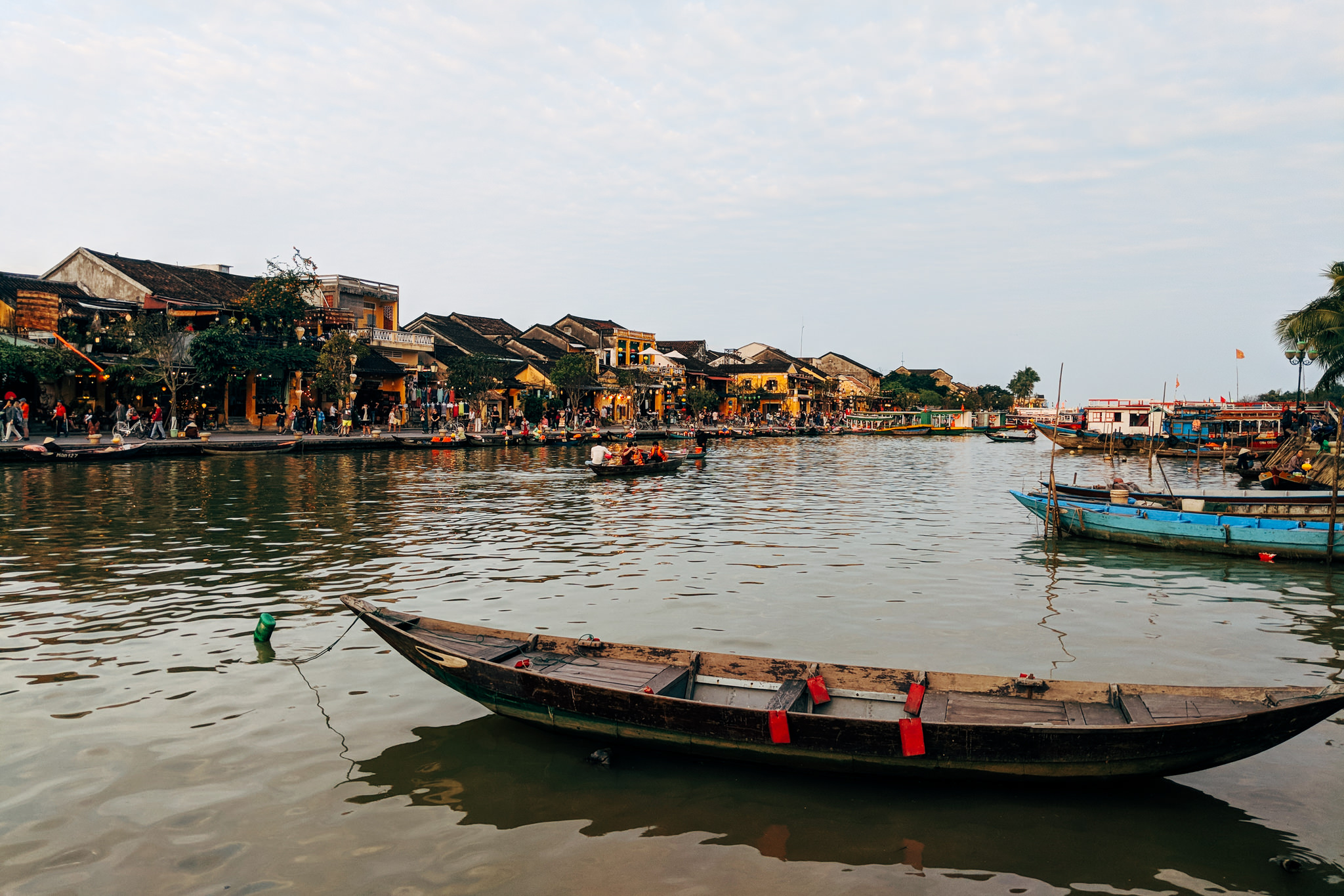 Hoi An, Vietnam: Old town waterfront with boats and people.