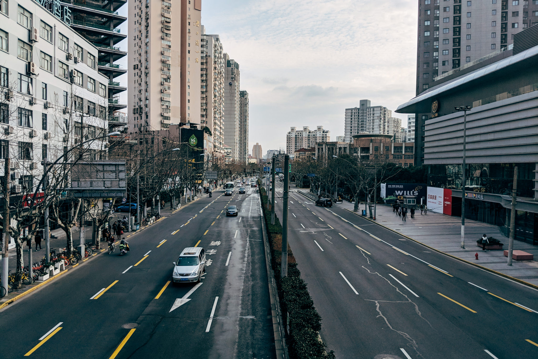 Shanghai street scene with tall buildings and sparse traffic.