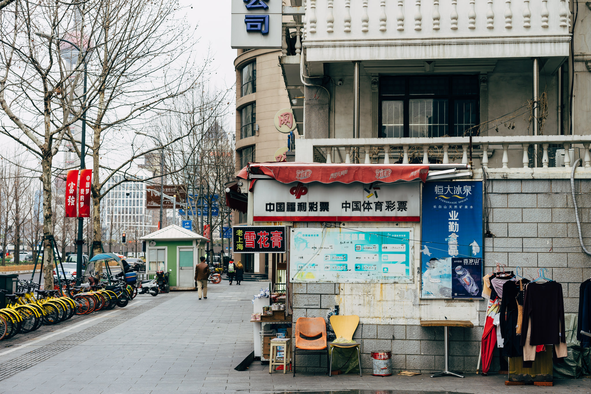 Shanghai street scene with a small shop selling lottery tickets and drinks, bicycles parked nearby.
