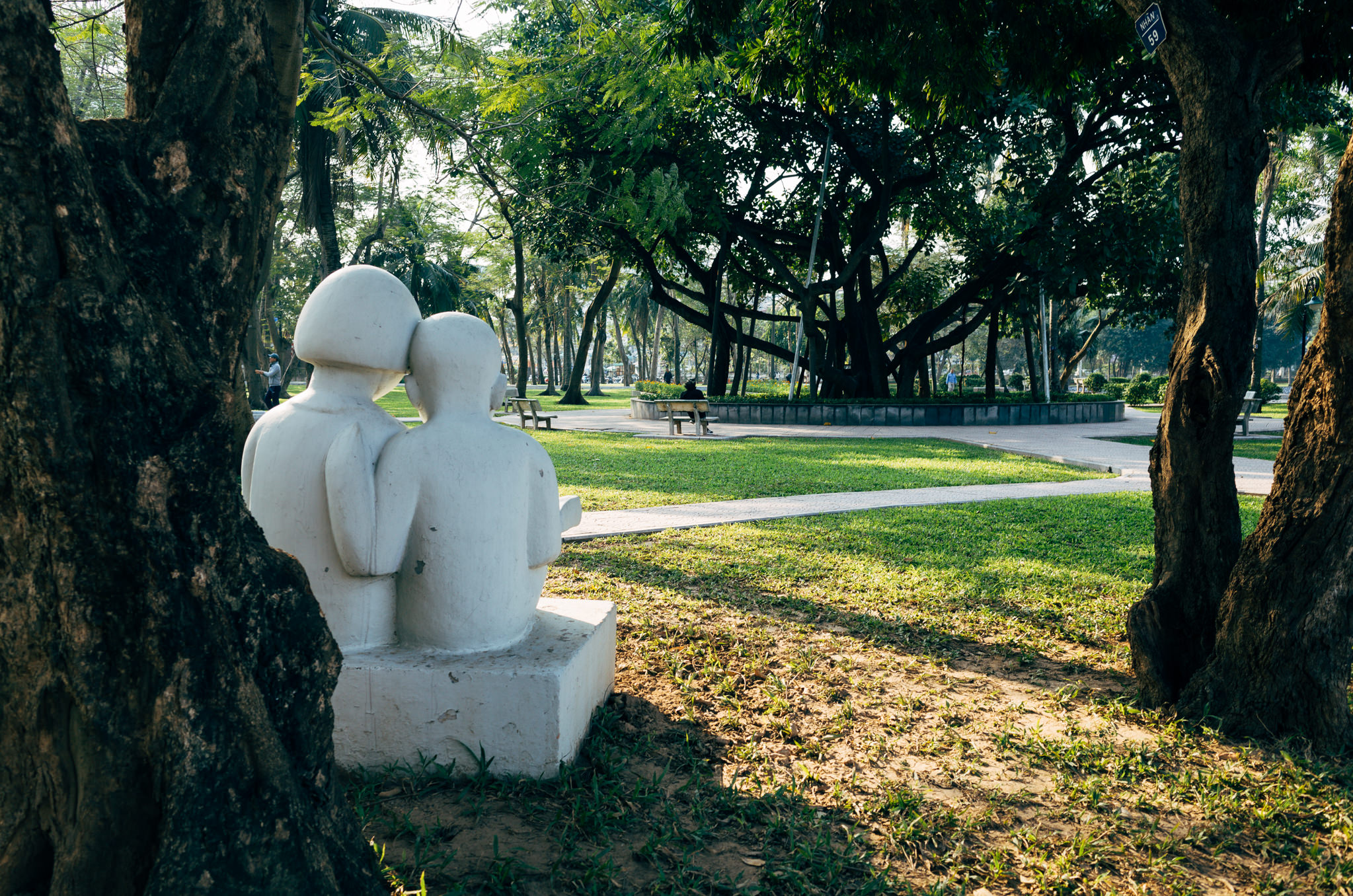 White statue of two people sitting in a Hanoi park.
