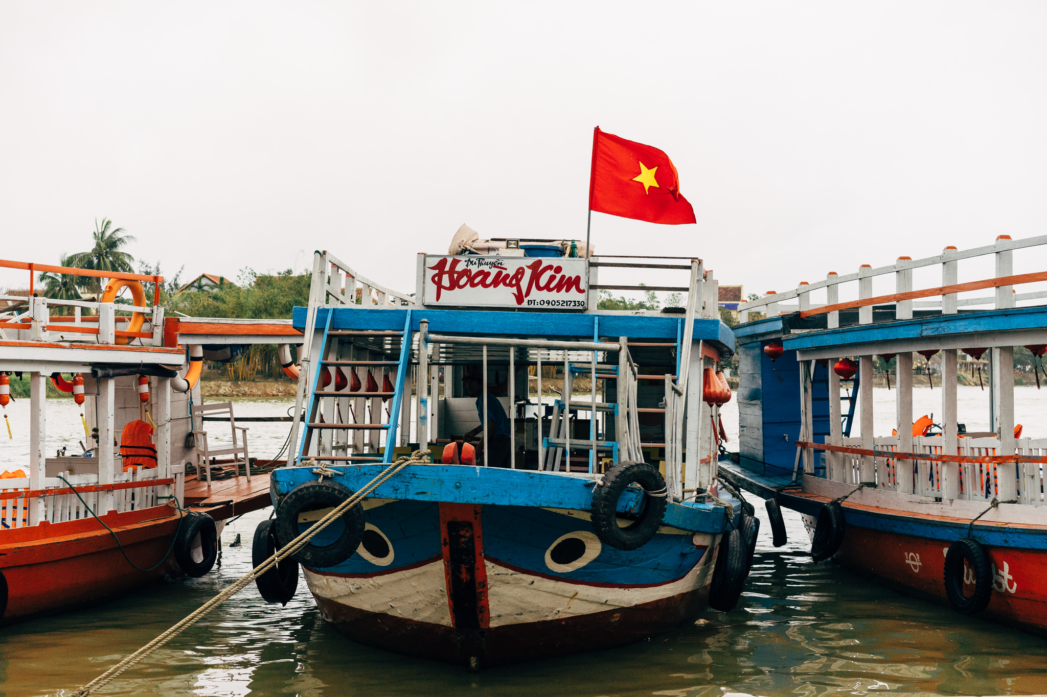Hoi An boat tour boat with Vietnamese flag.