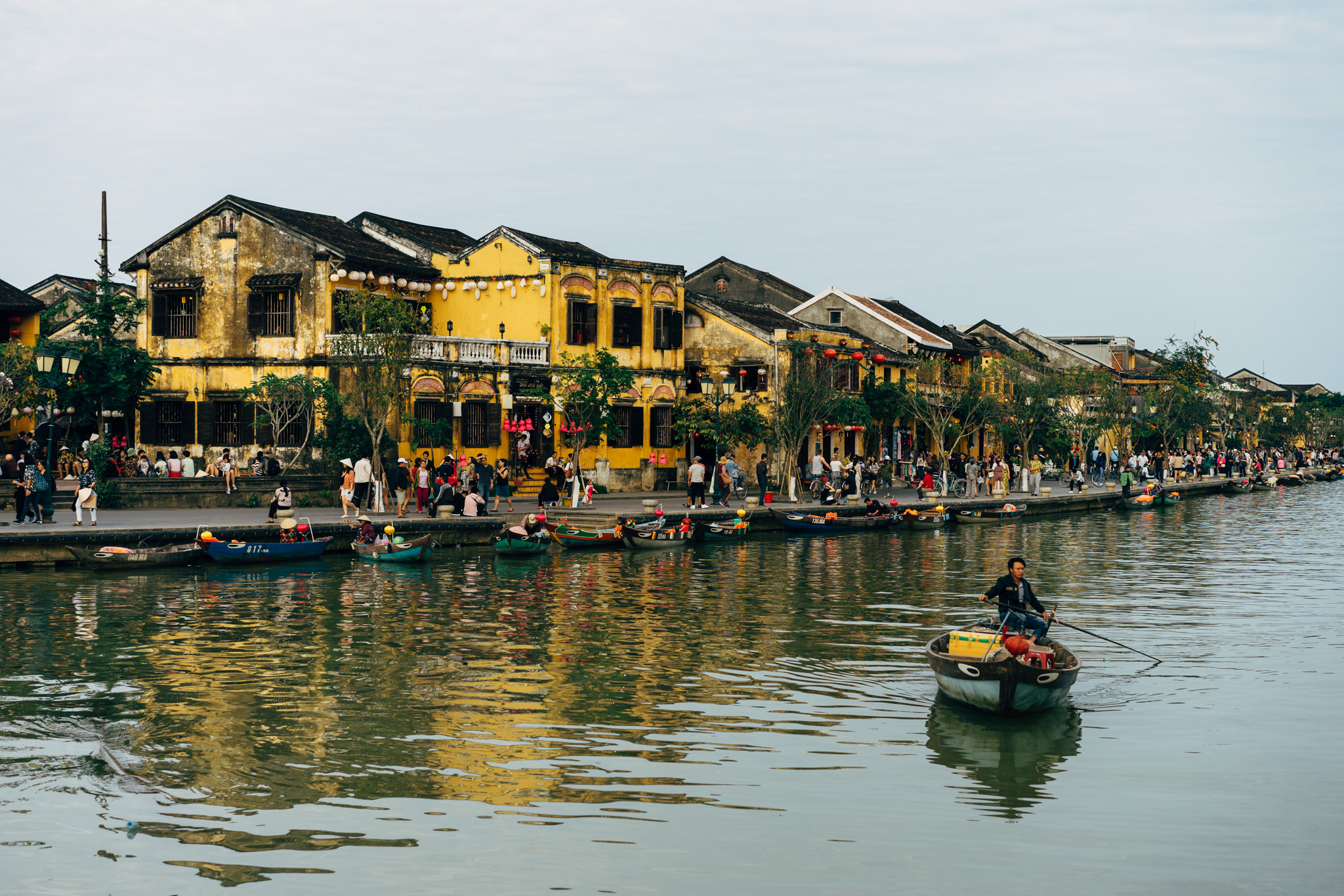 Hoi An river scene with colorful buildings and boats.