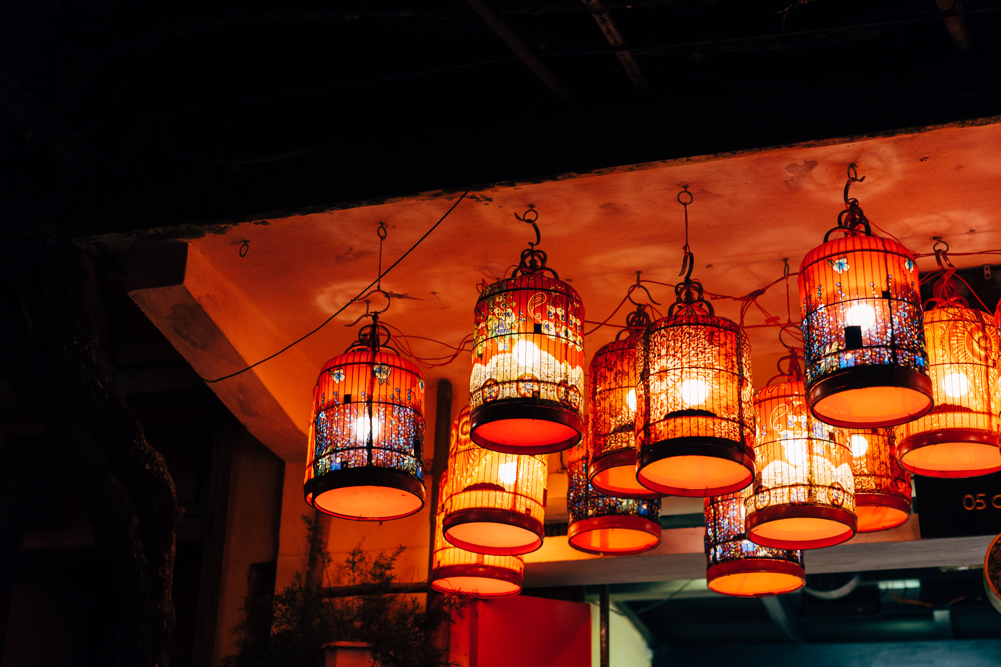 Illuminated lanterns hanging from a ceiling at night in Hoi An, Vietnam.