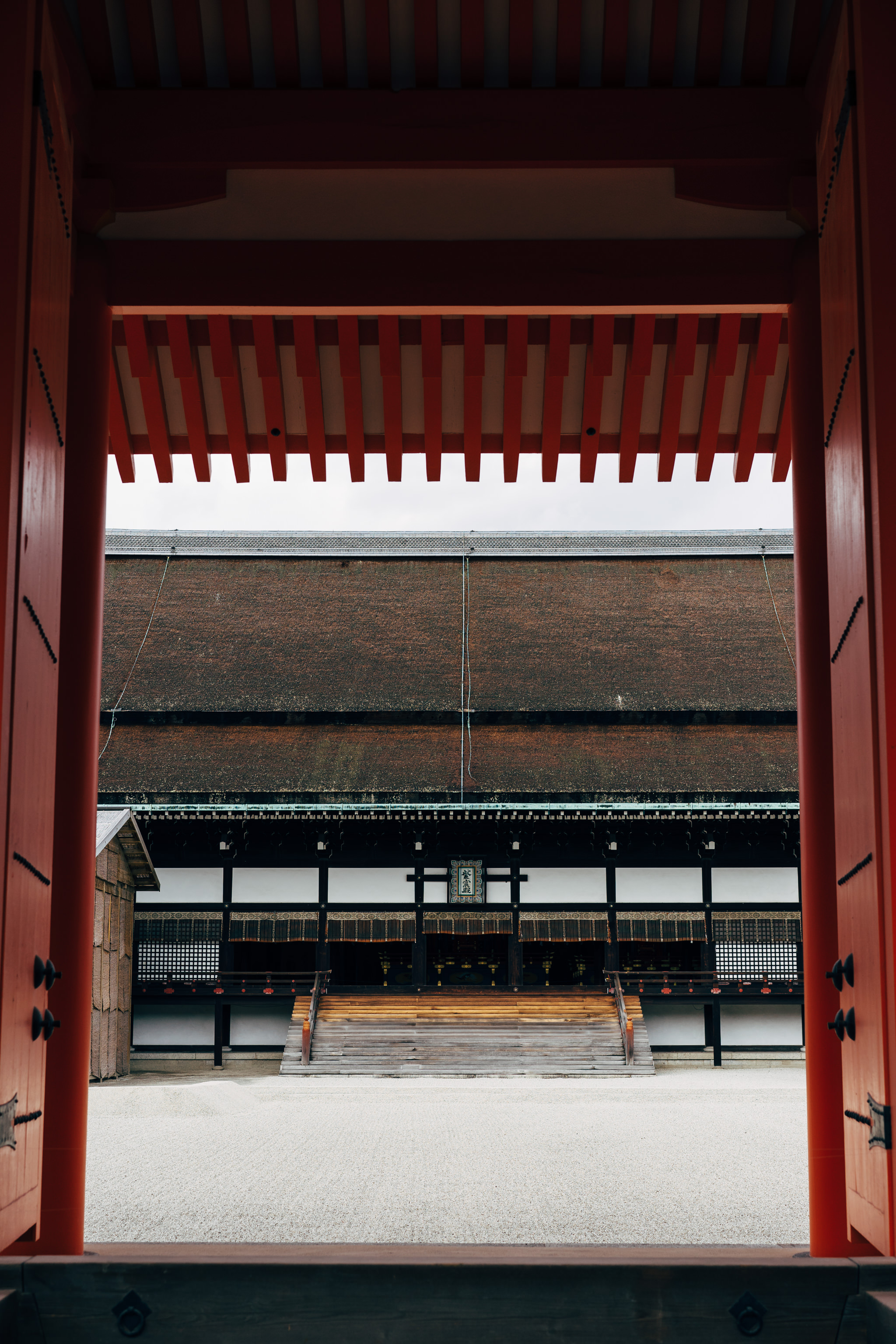 View of Kyoto Gosho through a red gate.