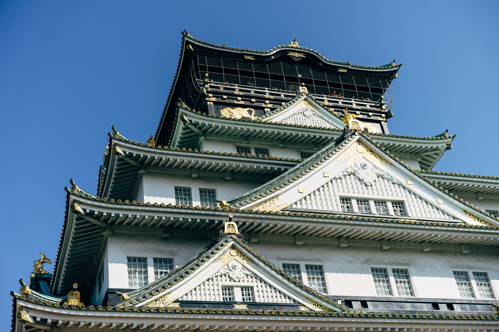 Osaka Castle, Japan: Close-up view of the castle's ornate roof and upper stories.