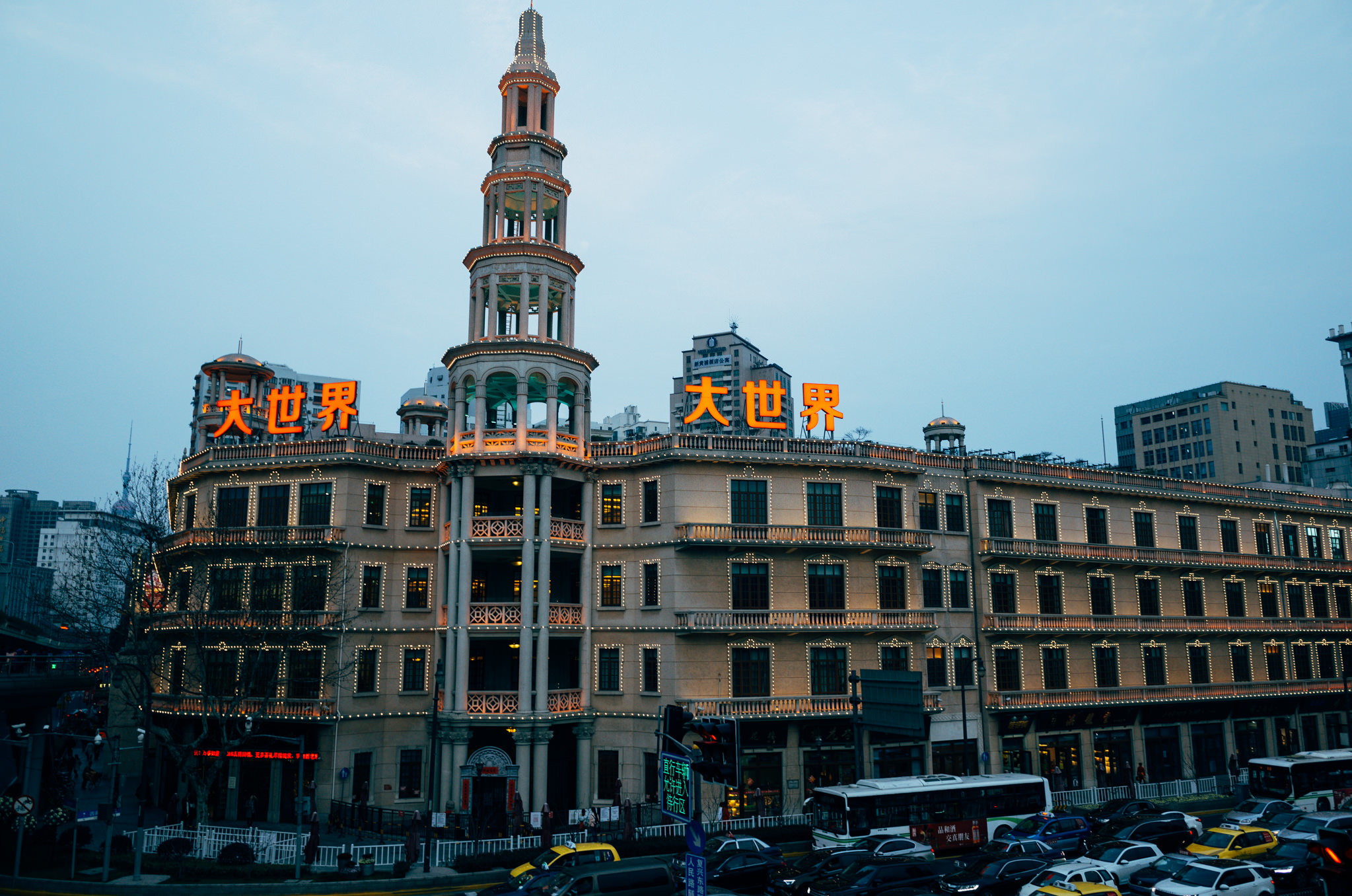 Shanghai's Great World building at night, illuminated with lights.