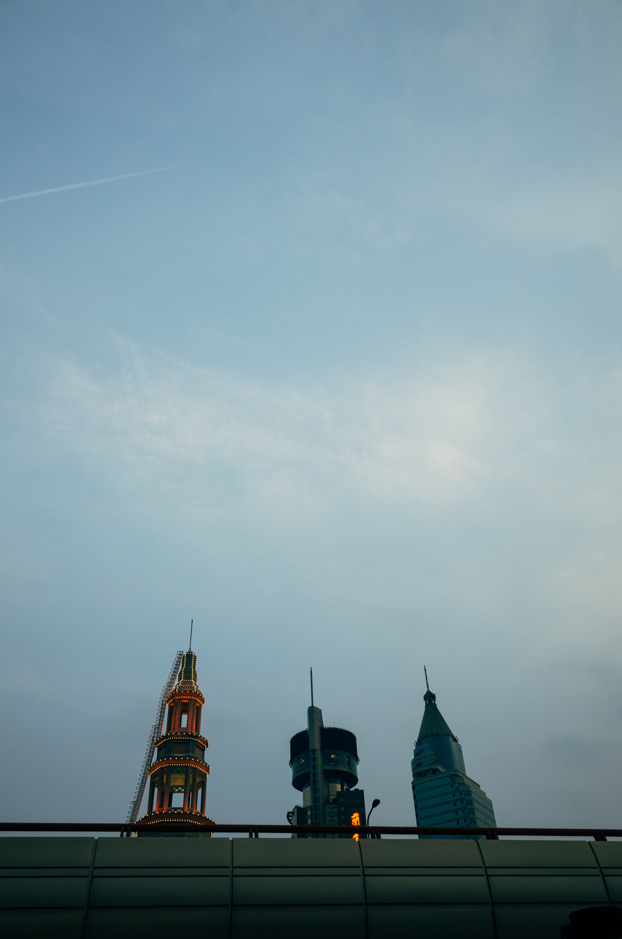 Shanghai skyline at dusk, featuring three buildings.