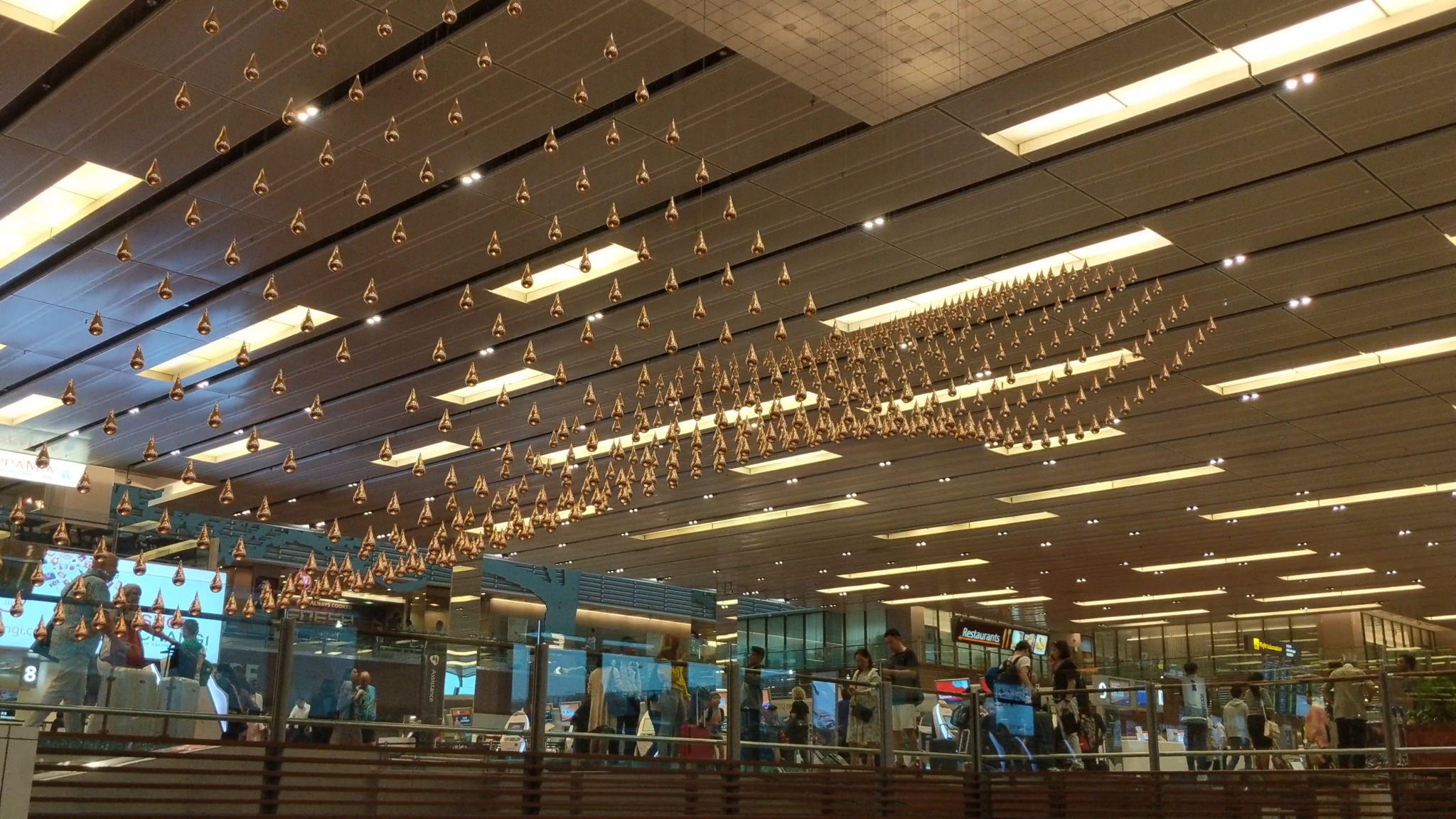 Singapore Changi Airport ceiling installation with numerous gold teardrop shapes.