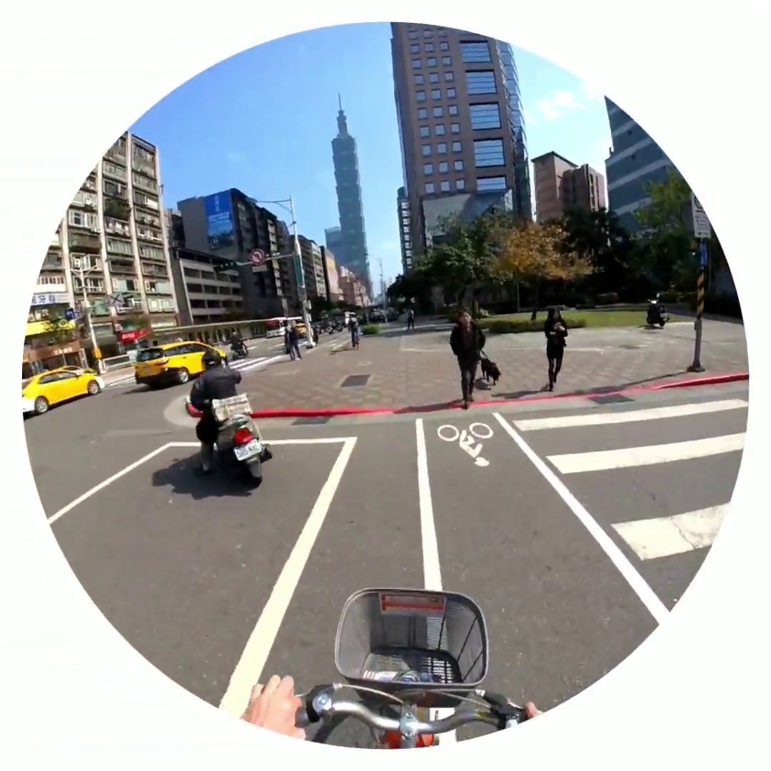 Cycling through Taipei, Taiwan, with Taipei 101 in the background.