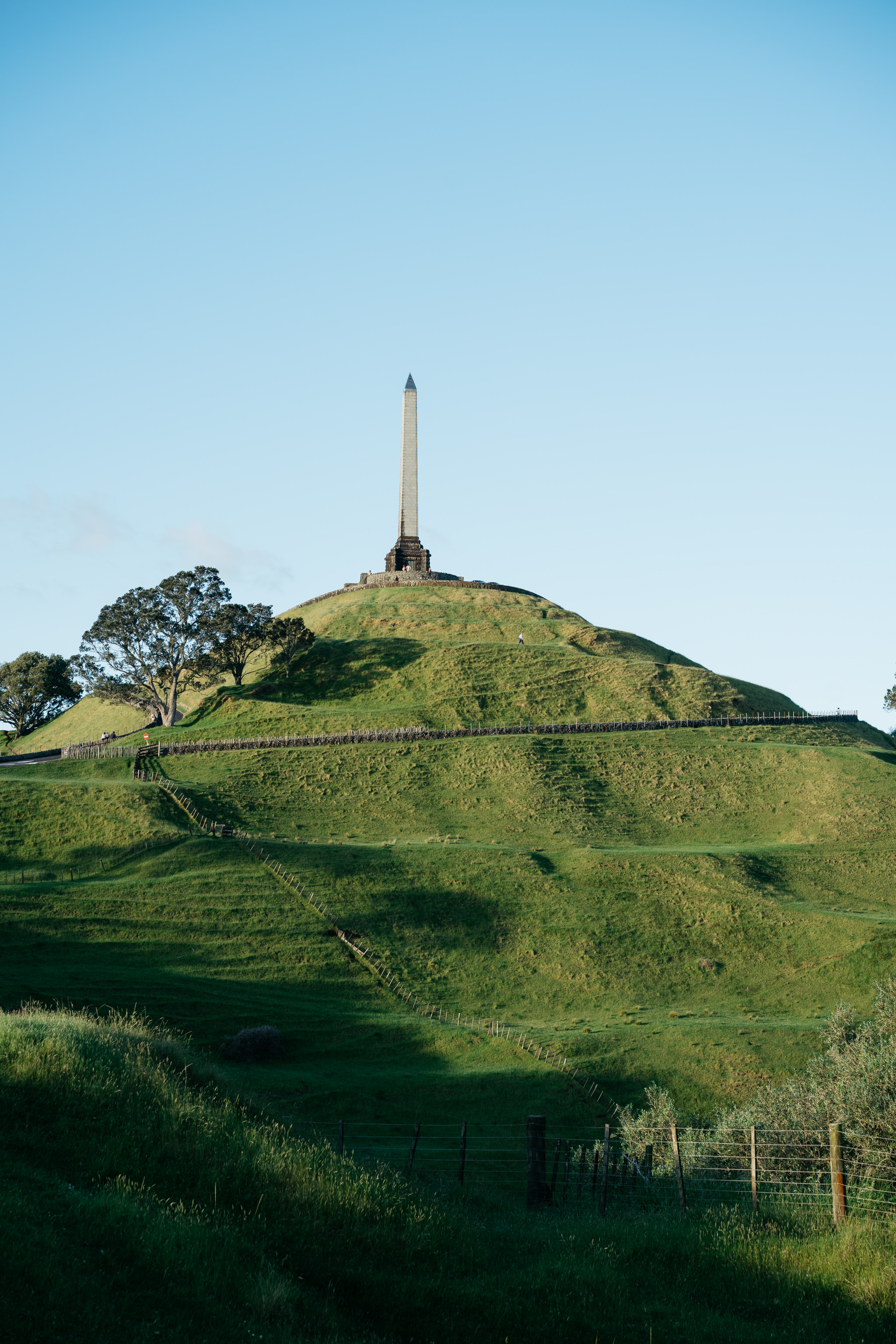 A tall obelisk atop a grassy hill in Auckland.