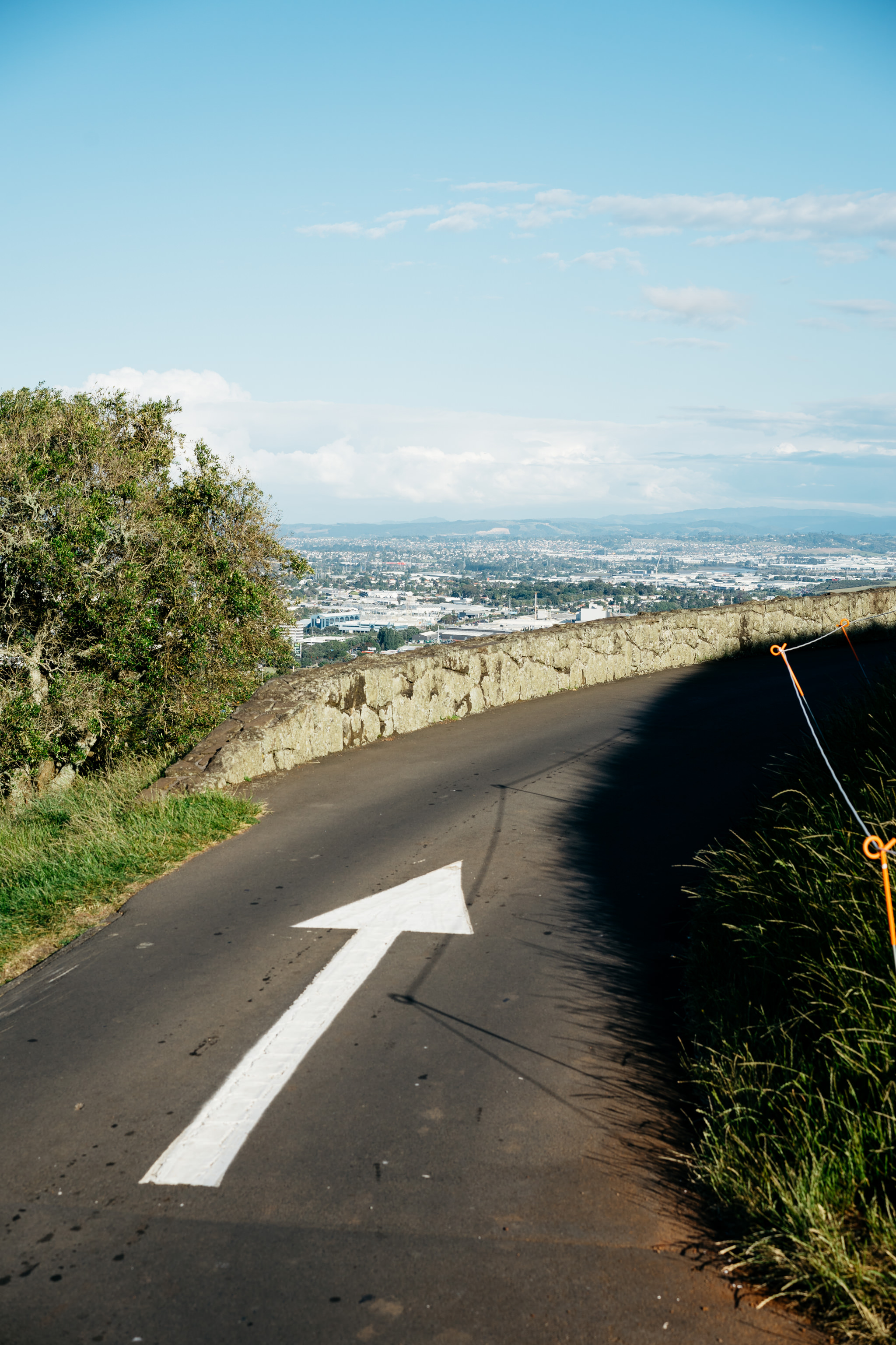 White arrow painted on a road overlooking Auckland city.