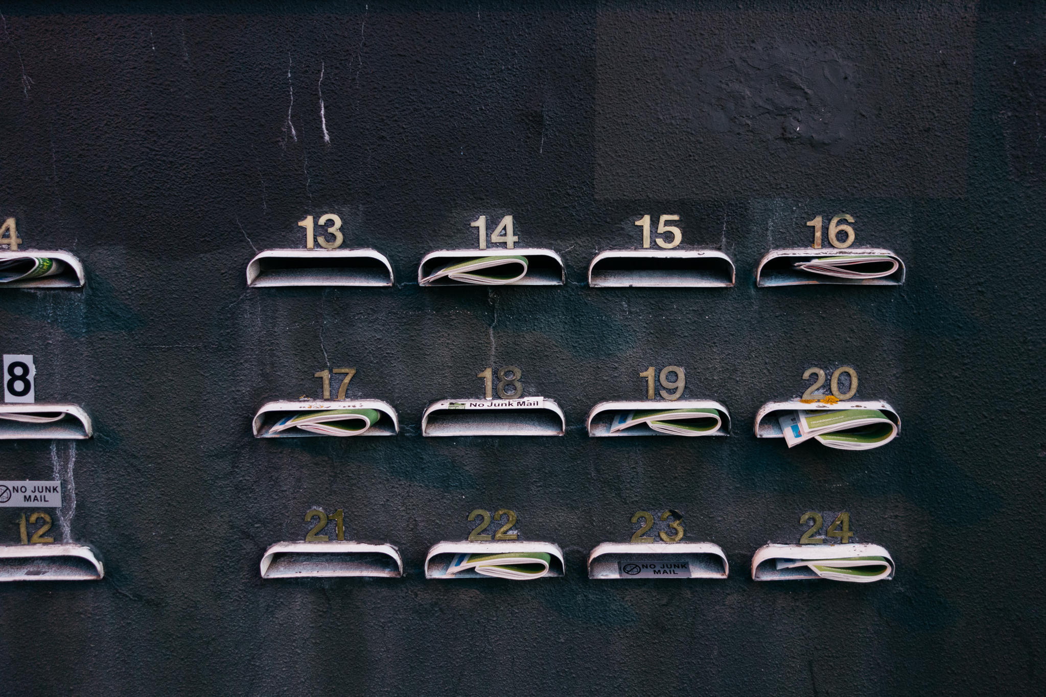 Bank of numbered mailboxes with some containing mail.