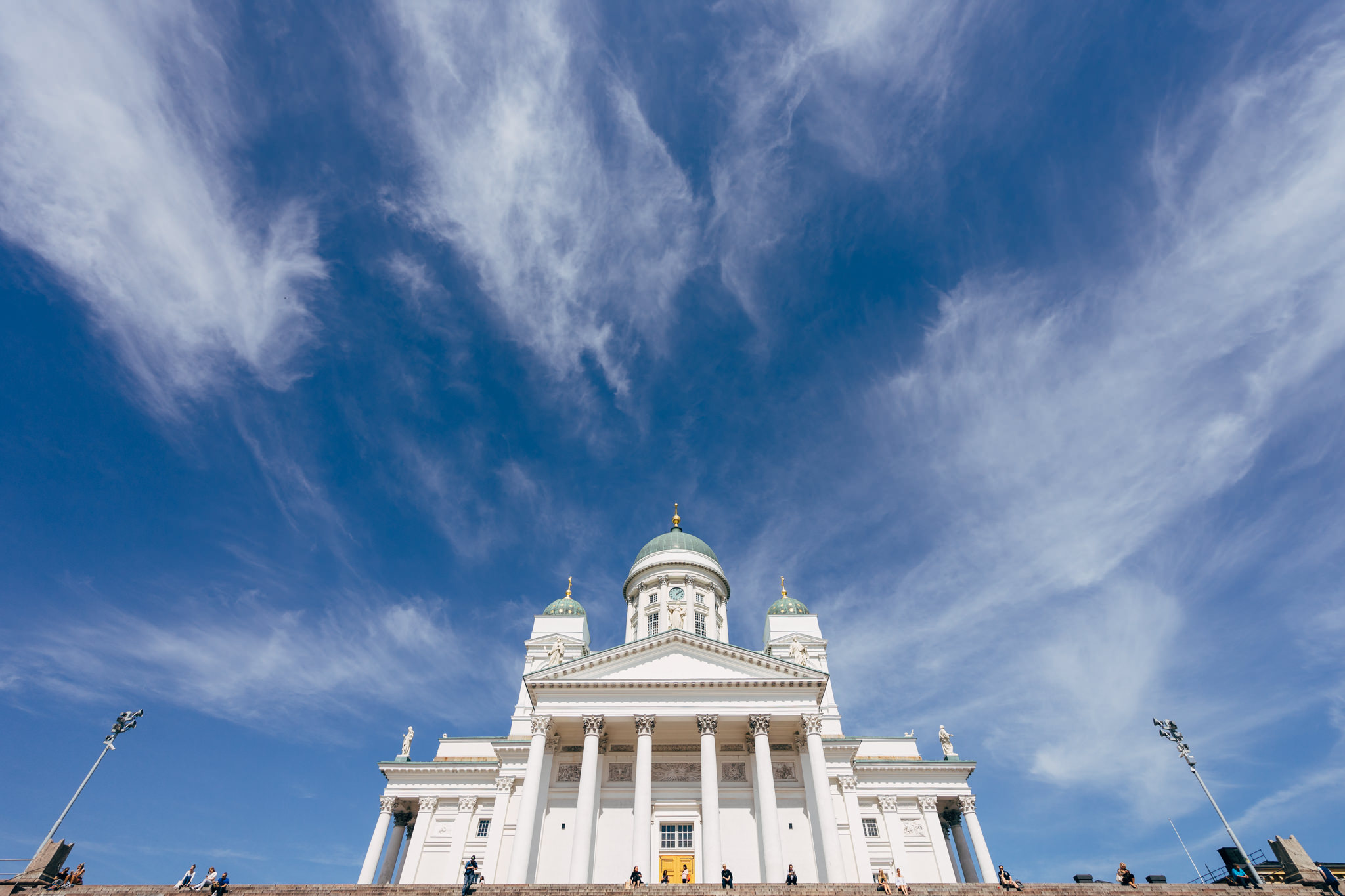 Helsinki Cathedral under a bright blue sky with wispy clouds.