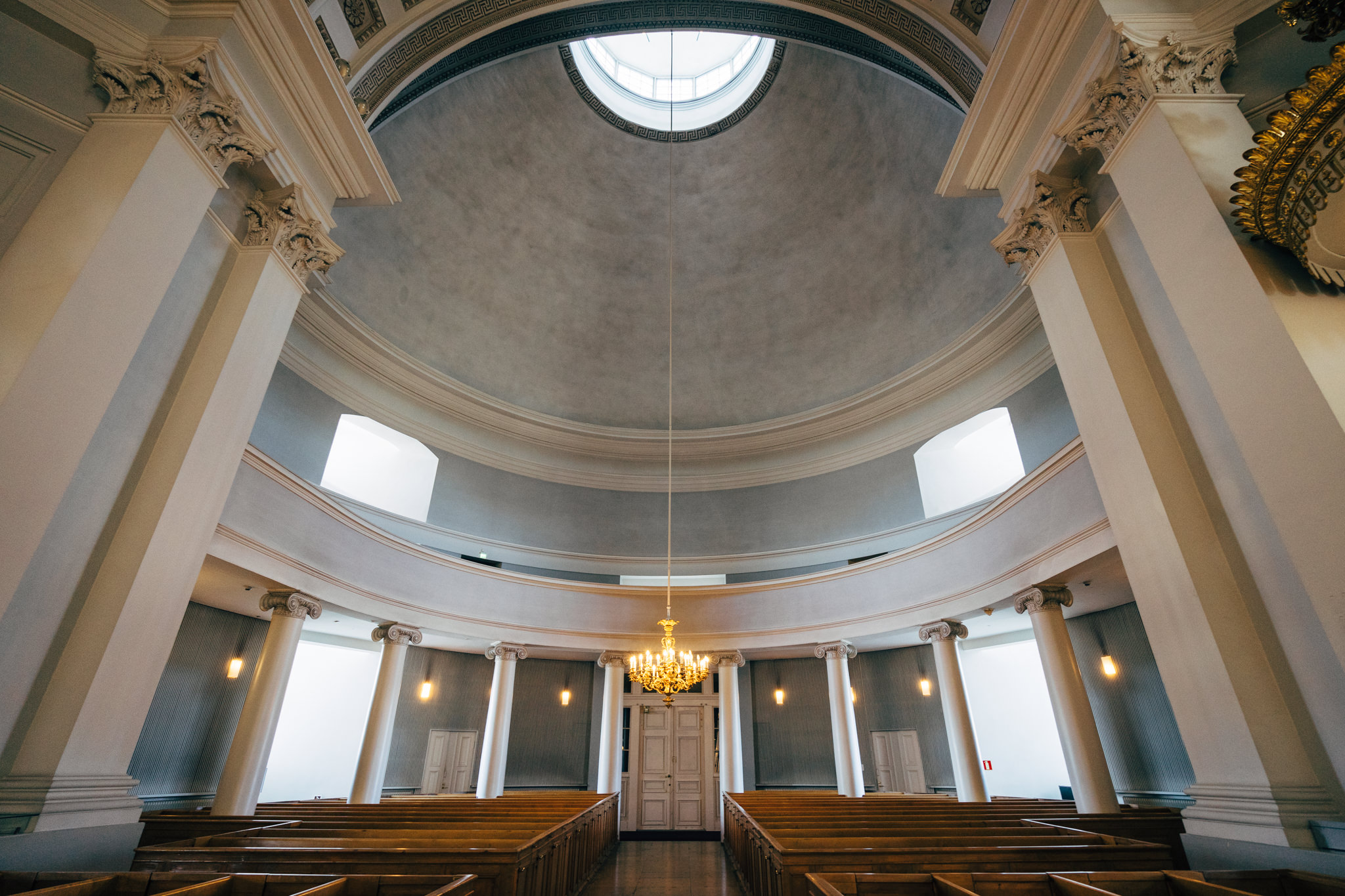 Interior of Helsinki Cathedral, showing its dome, columns, and pews.