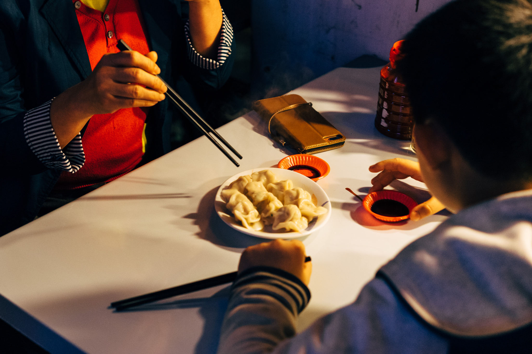 Two people eating dumplings at a table in Taiwan.