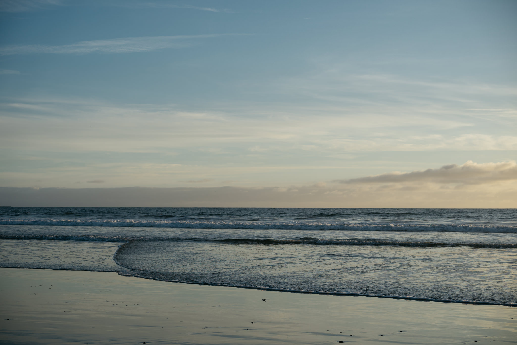 Santa Monica beach sunset with waves gently lapping the shore.