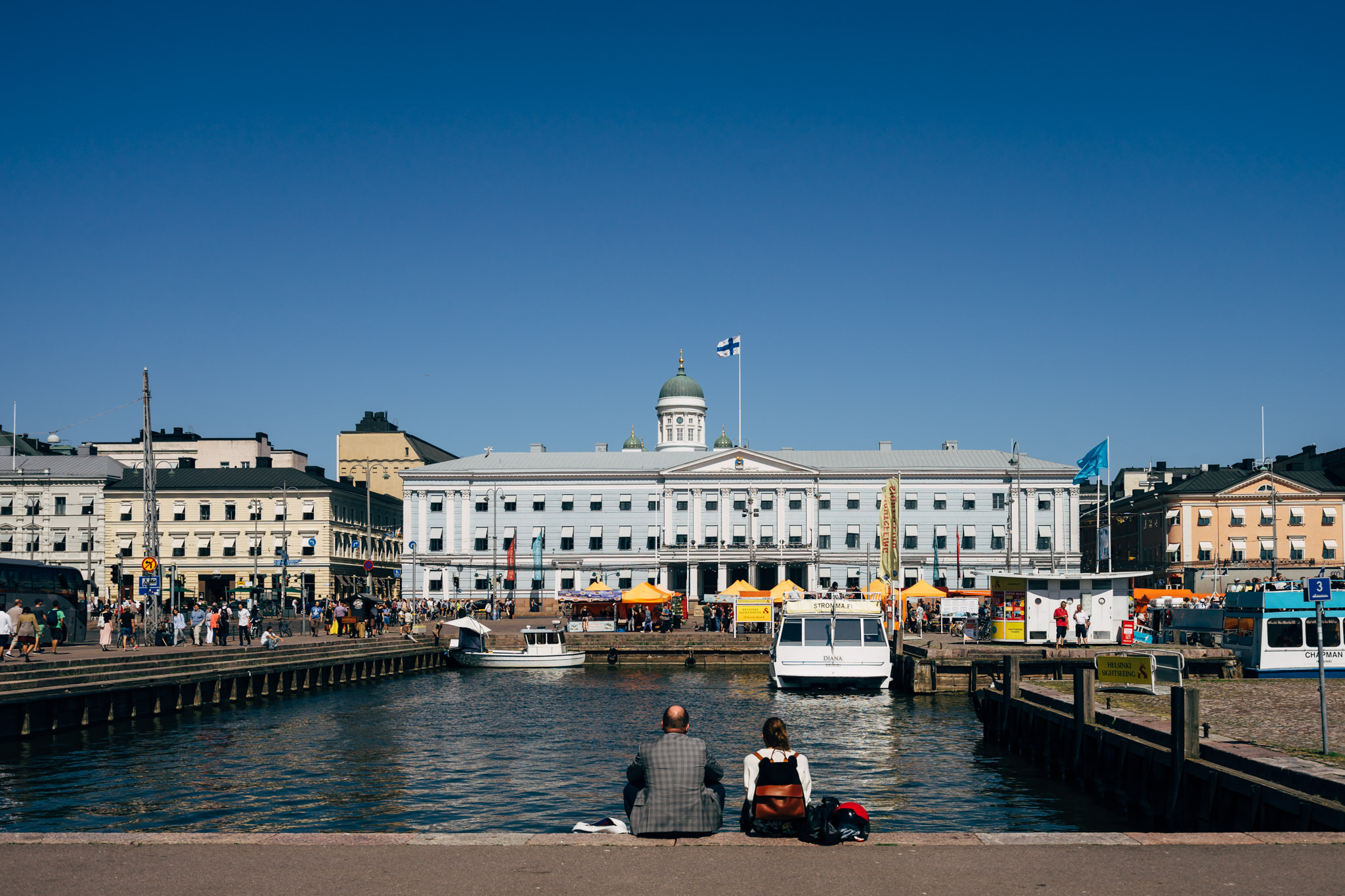 Helsinki Senate Square with a couple sitting by the water.