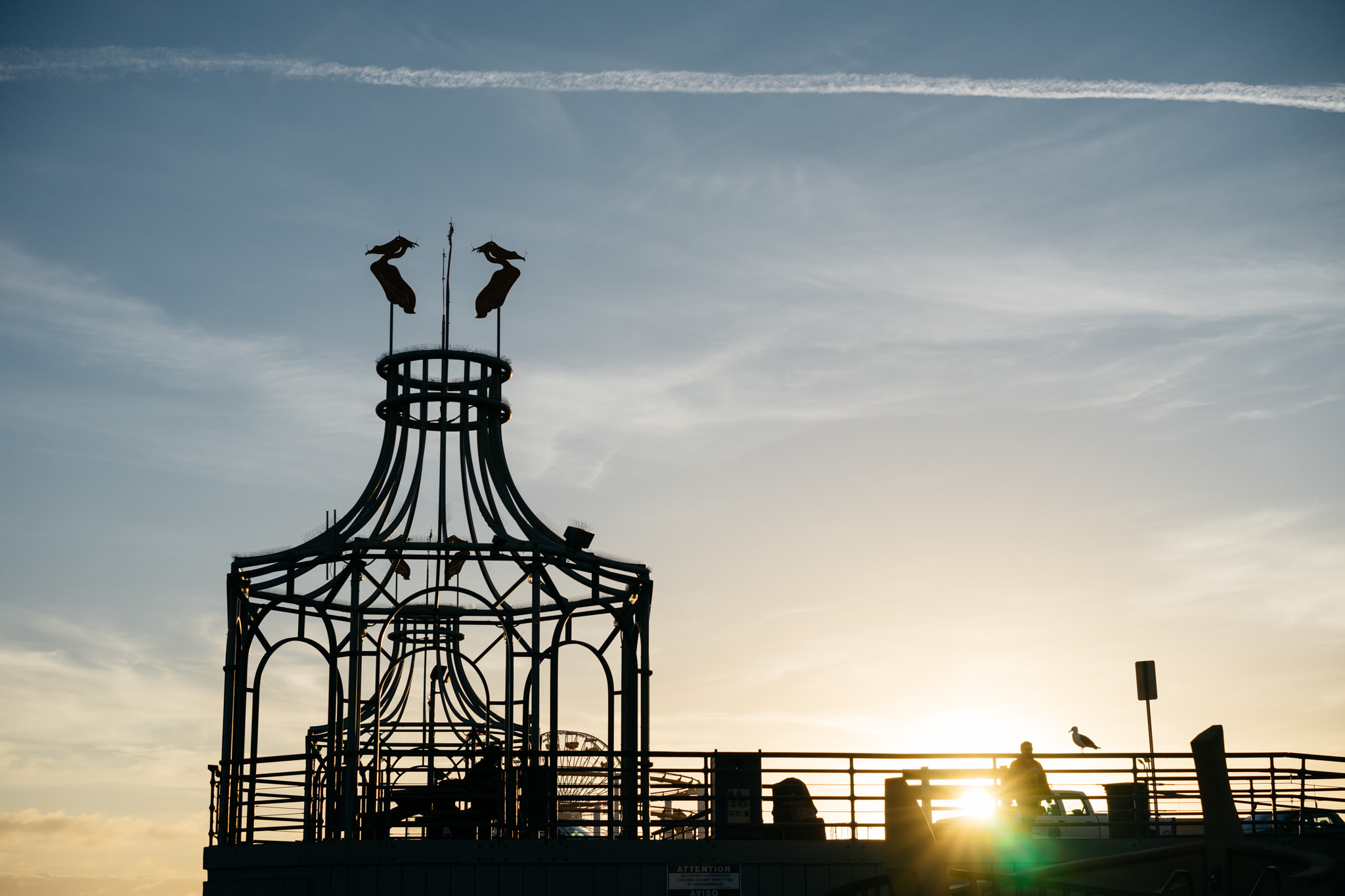 Silhouette of a pier structure at sunset in California.