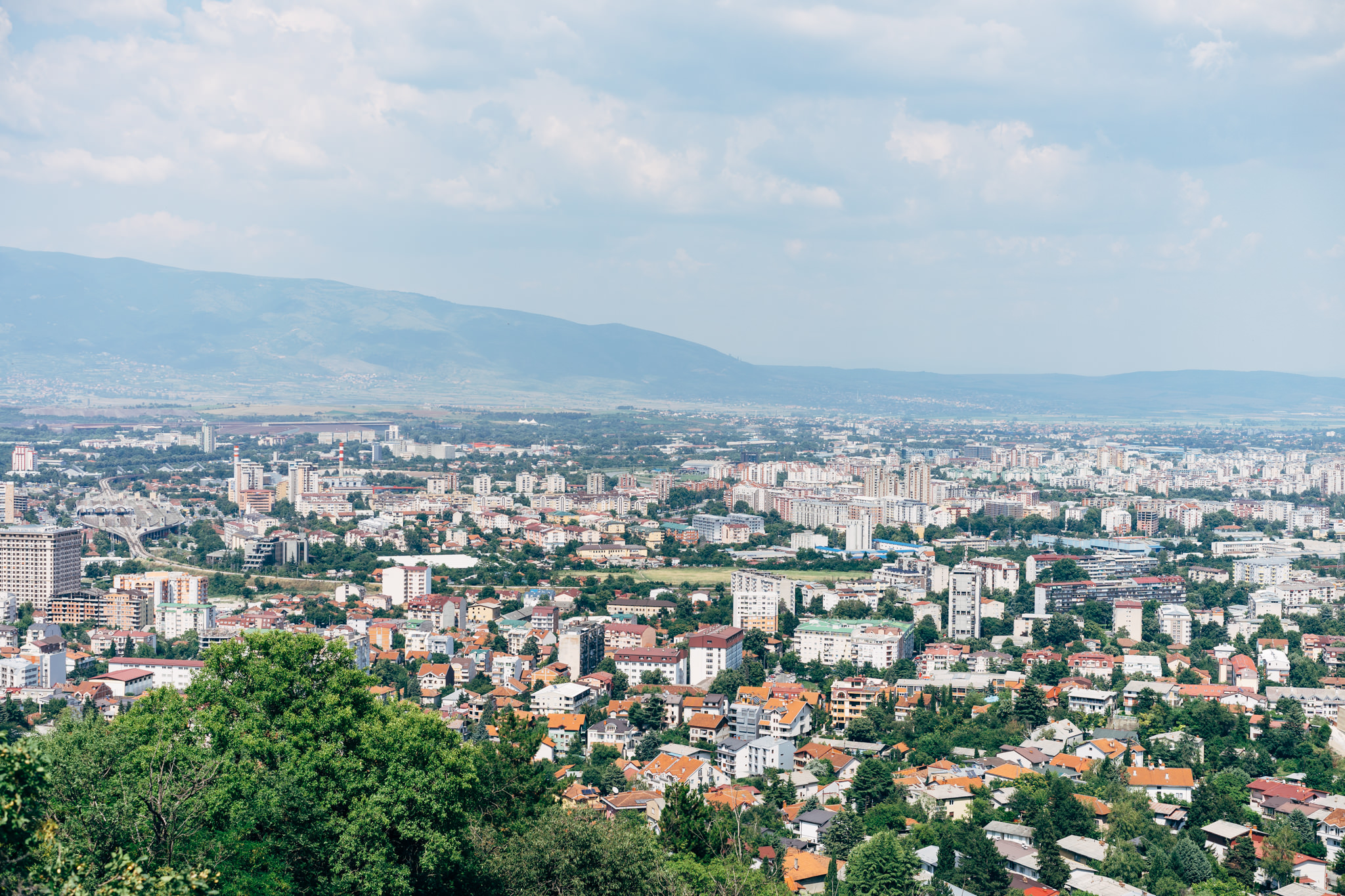 Aerial view of Skopje, Macedonia, showing the city spread out beneath mountains.