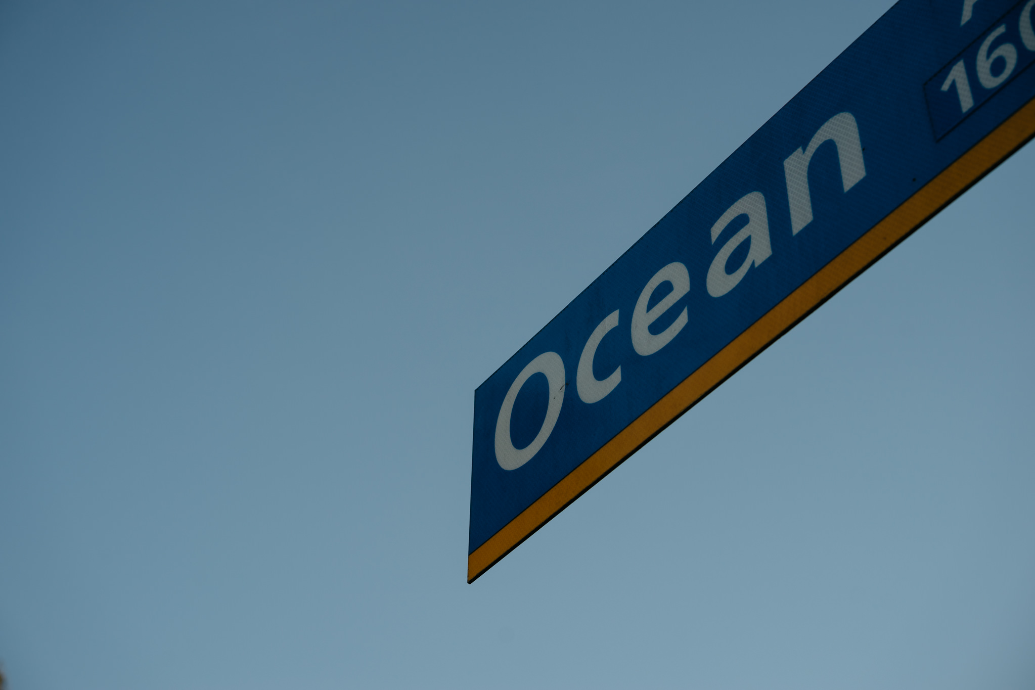 Ocean street sign against a blue sky.