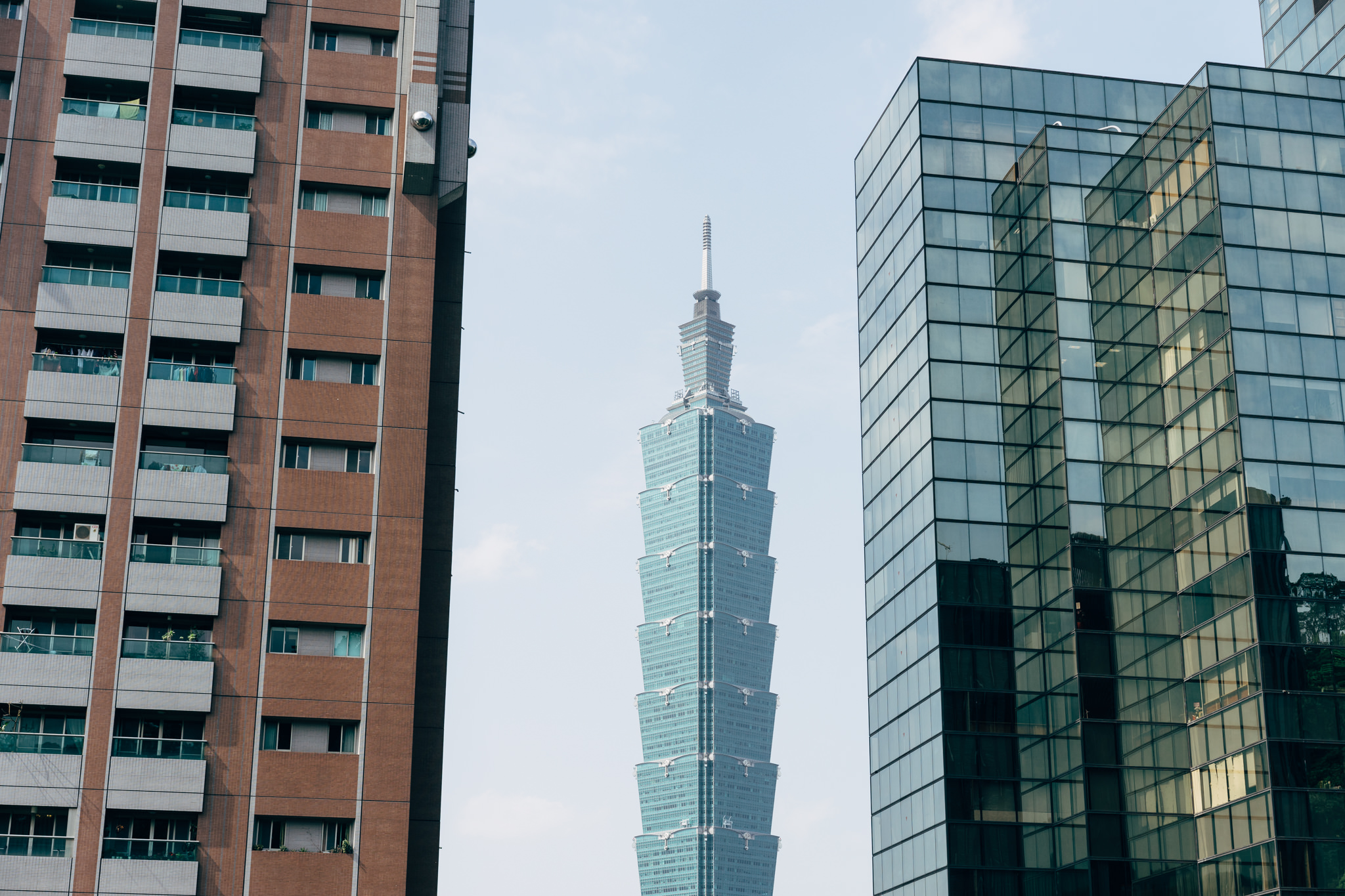Taipei 101 tower viewed between two buildings.