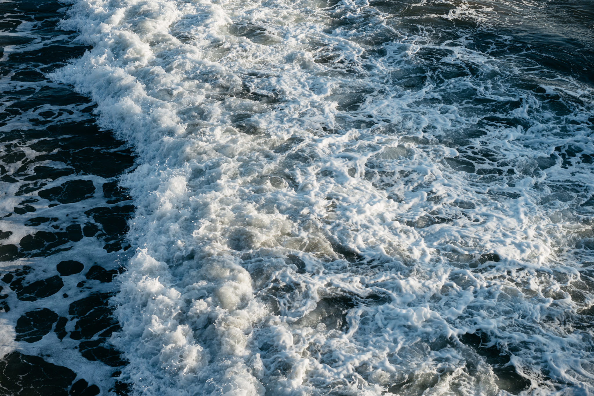 Overhead view of white capped waves in the Santa Monica ocean.