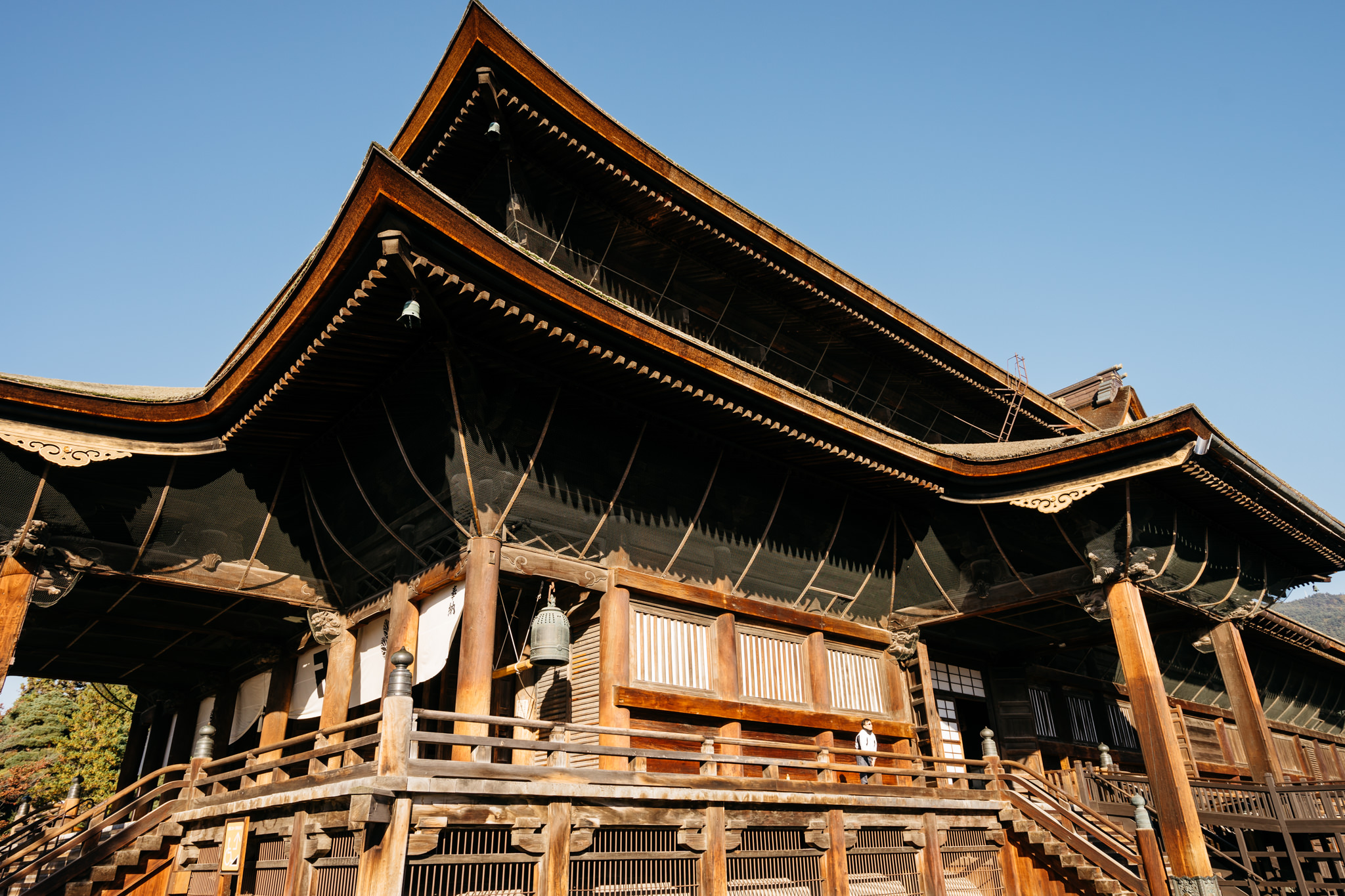 Low-angle view of Zenko-ji Temple's wooden main hall in Nagano, Japan.
