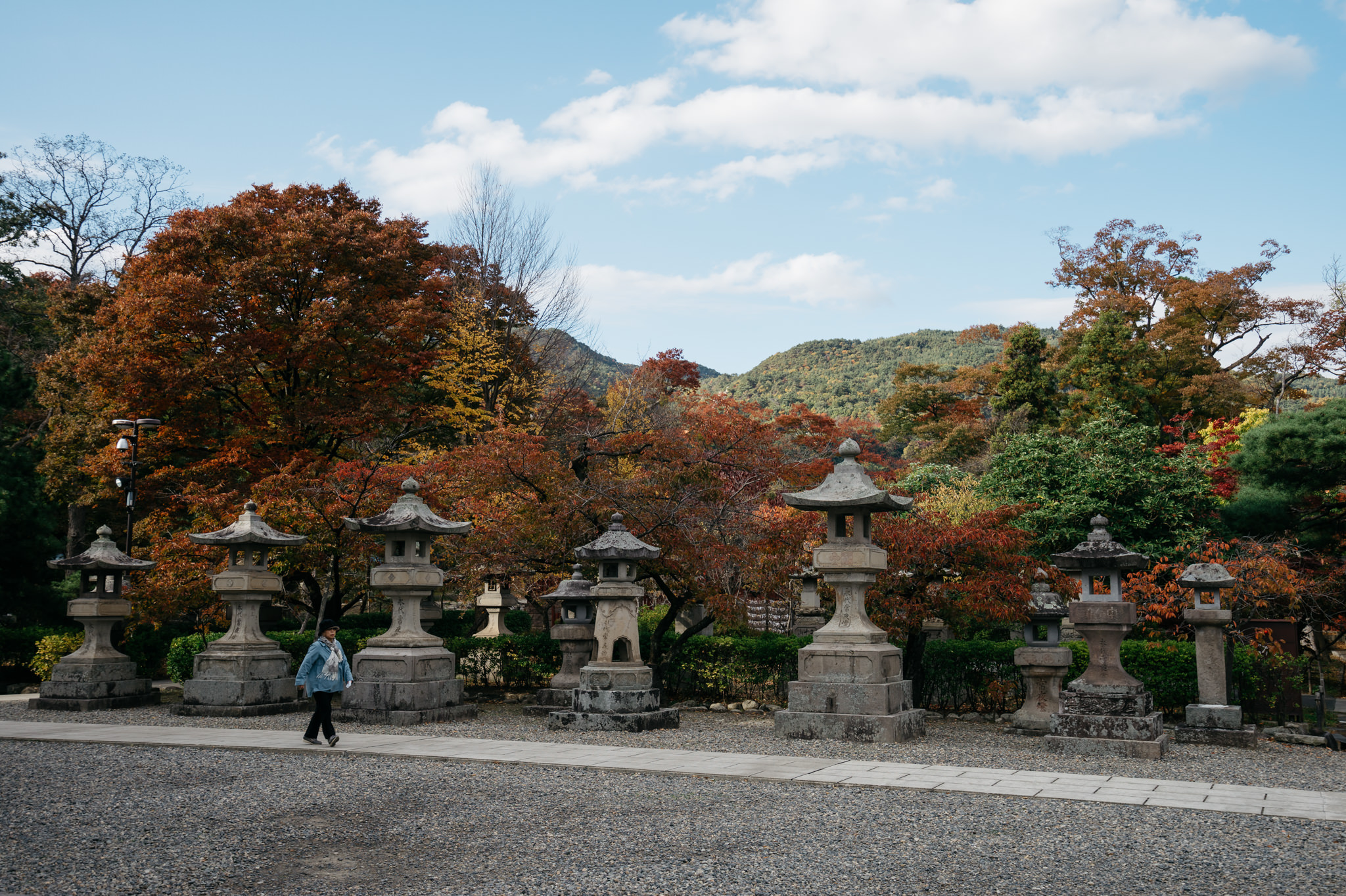 Stone lanterns in a Japanese garden during autumn.