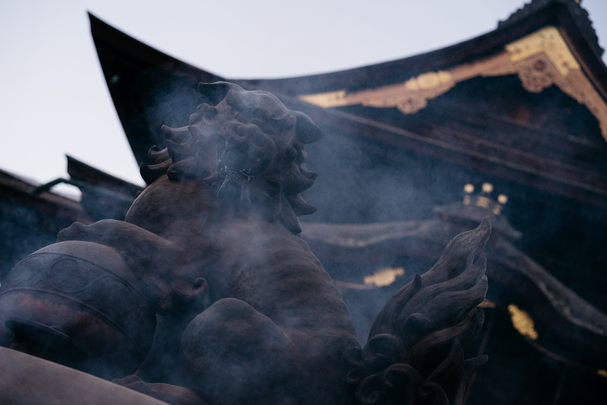 Smoke-shrouded komainu statue in front of Zenko-ji Temple.