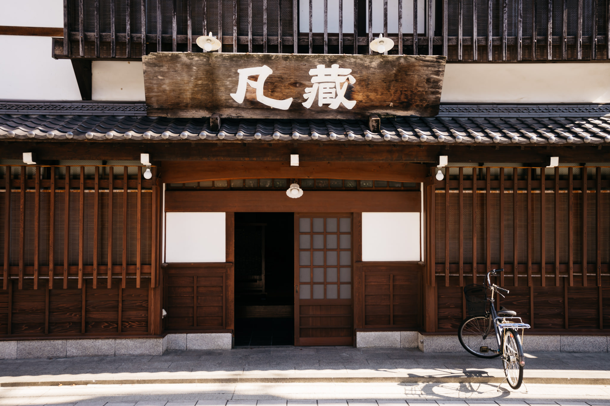 Bicycle parked in front of a traditional Japanese house.