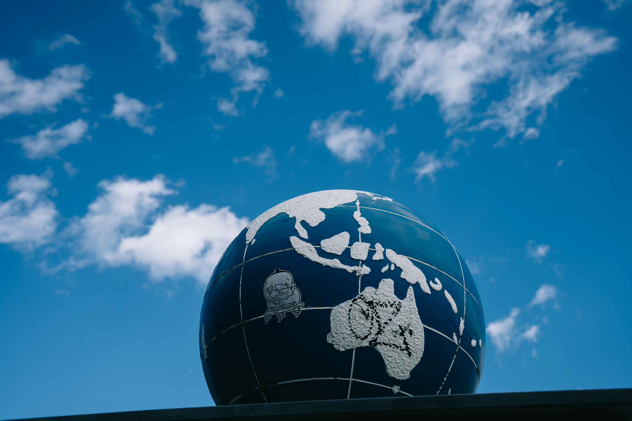 Blue globe against a bright blue sky.