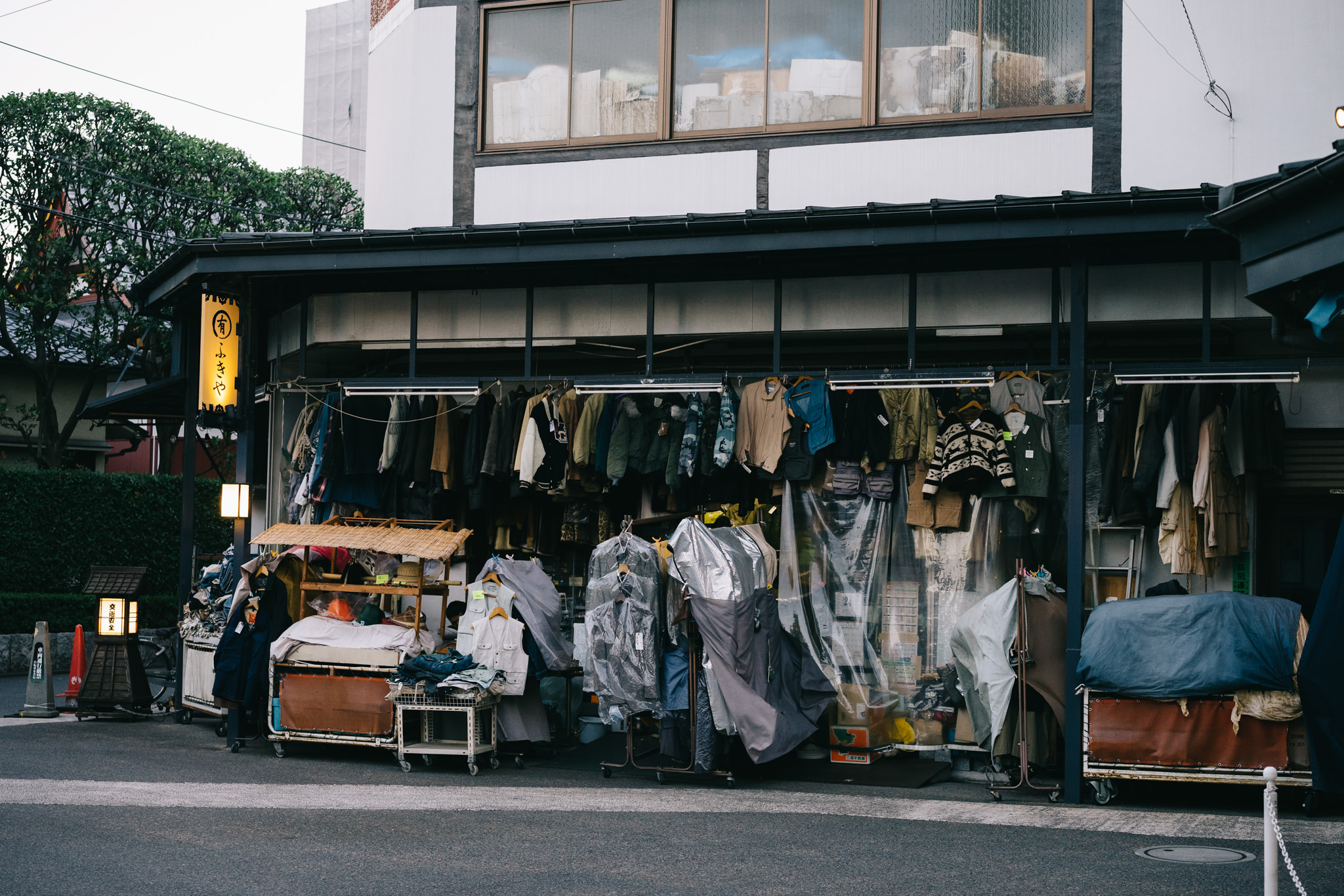 Tokyo clothing shop with clothes hanging outside.