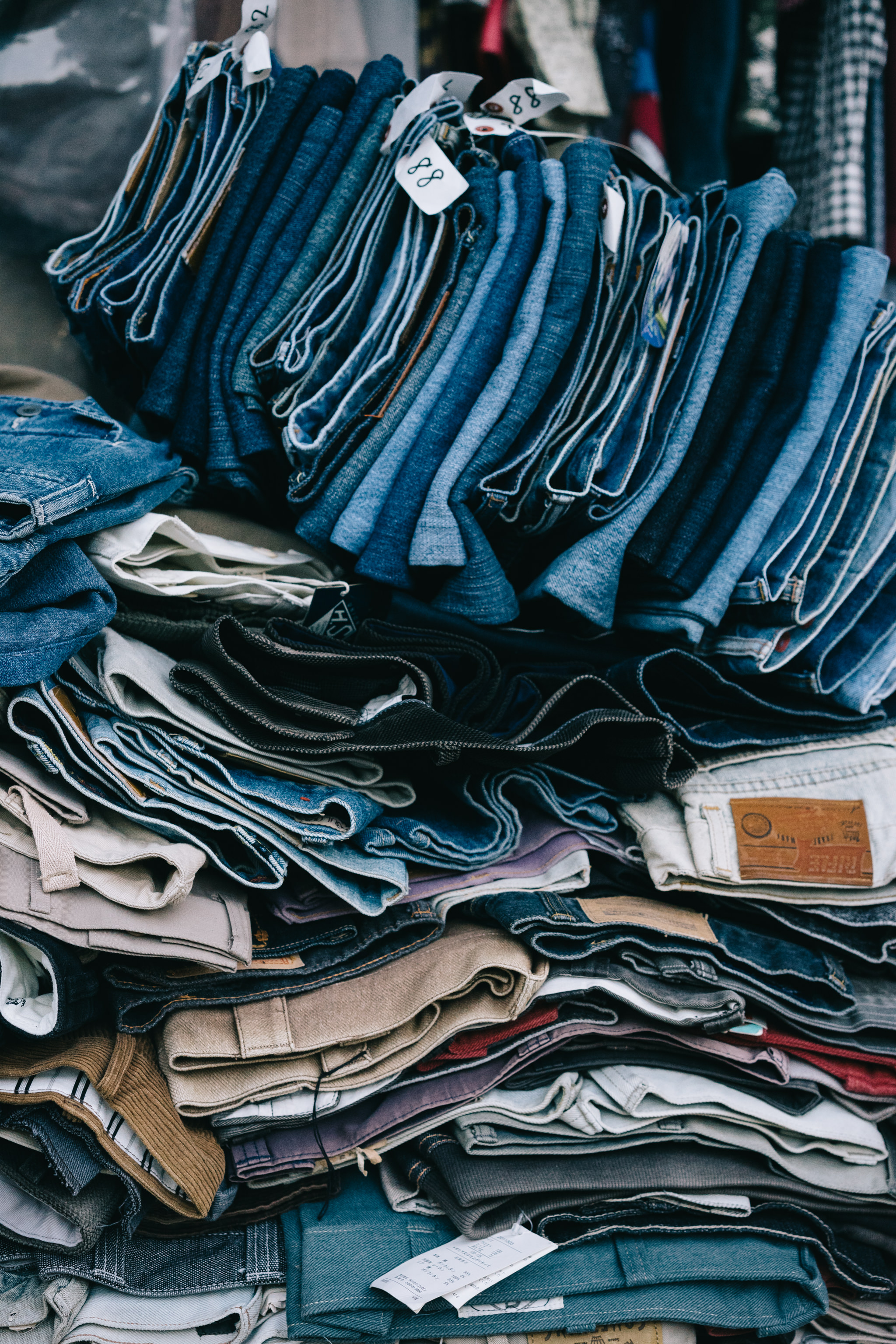 Large stack of folded jeans and pants.