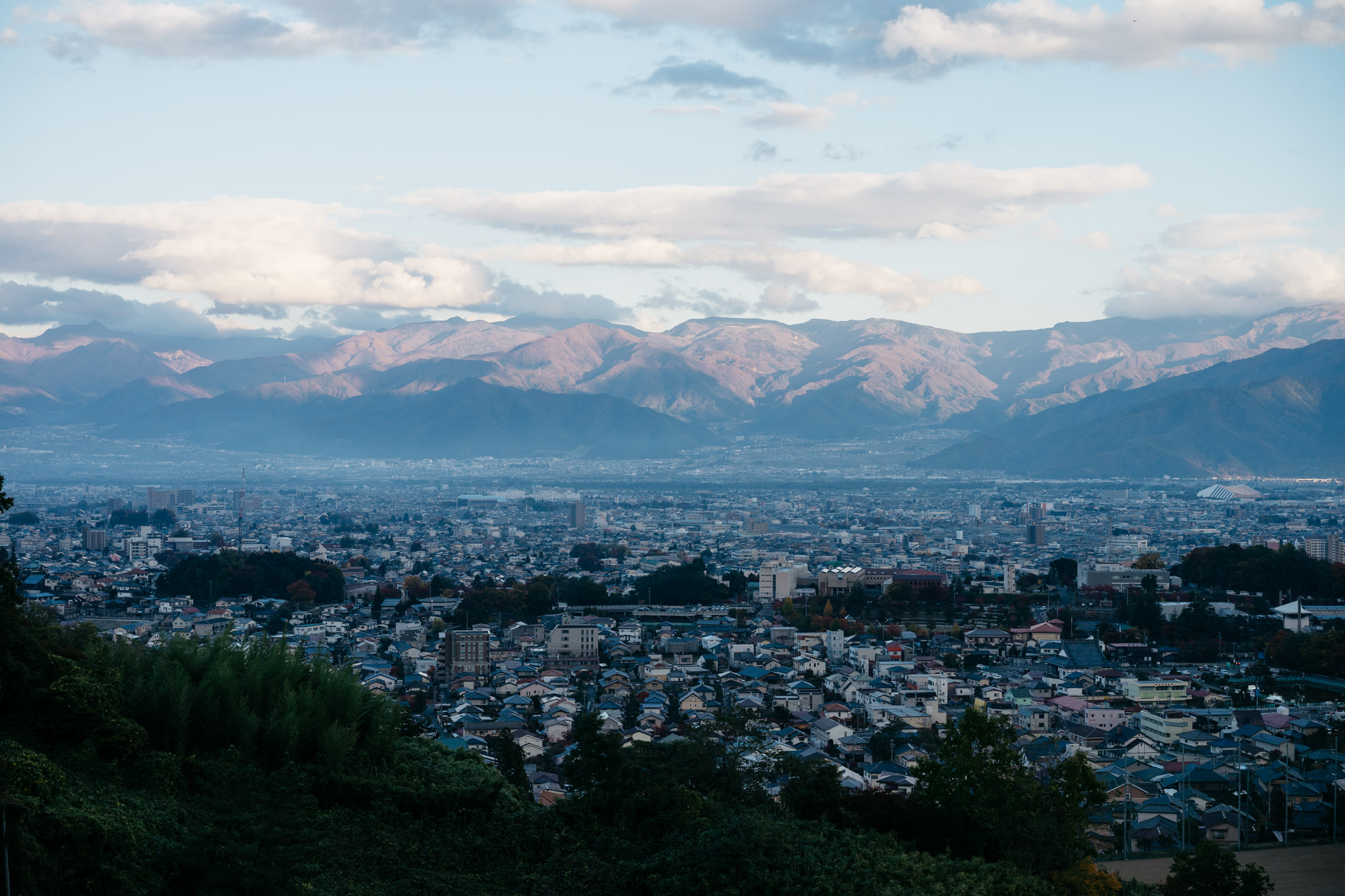 Nagano, Japan cityscape with mountains in the background.