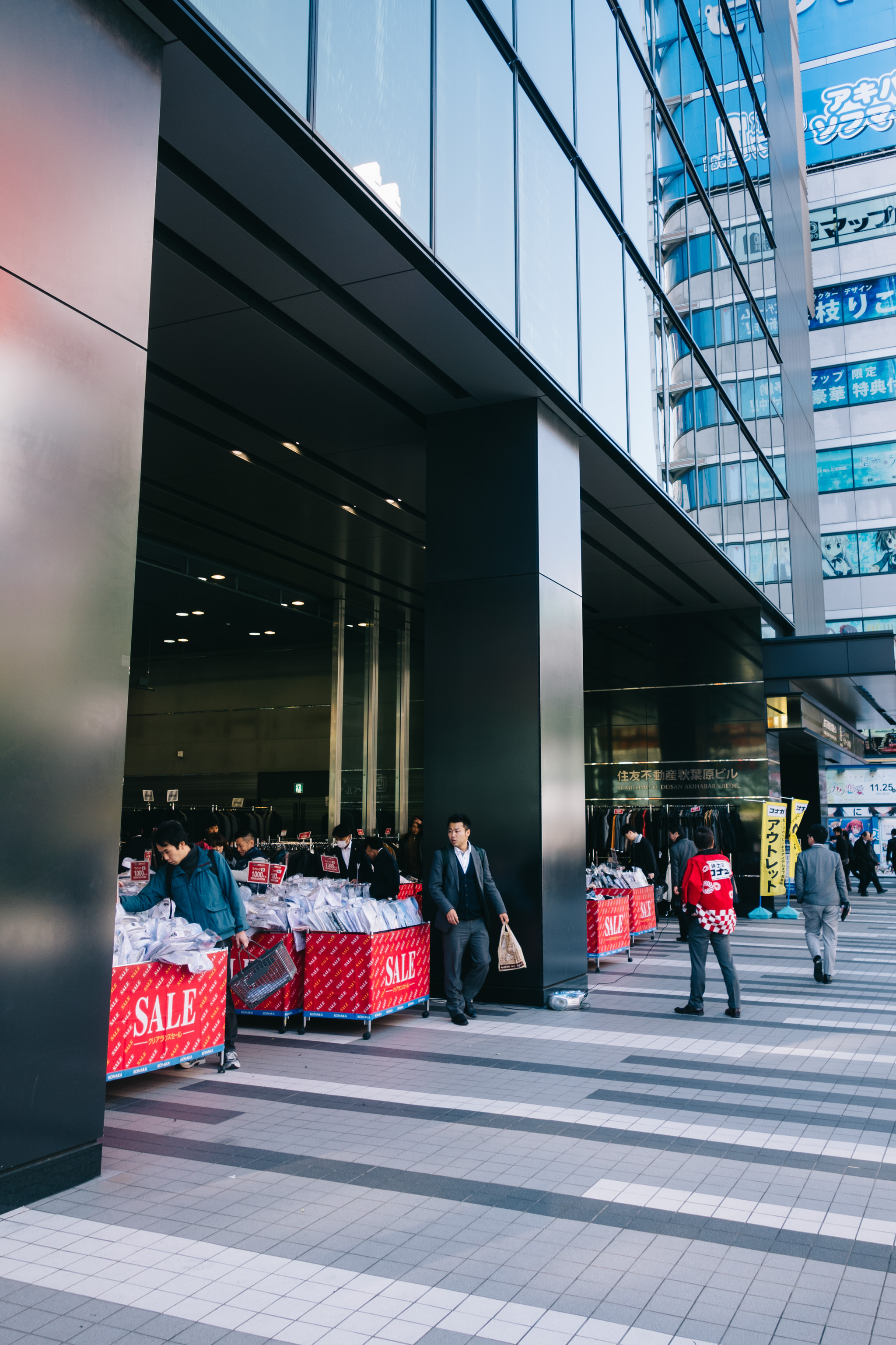Tokyo street scene: sale outside a modern building.