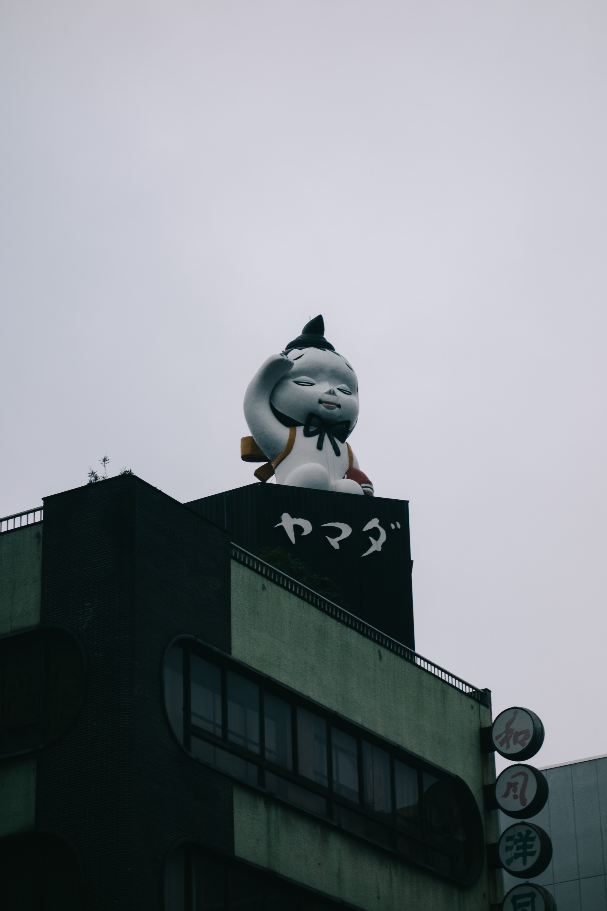 Large statue of a child atop a Tokyo building.